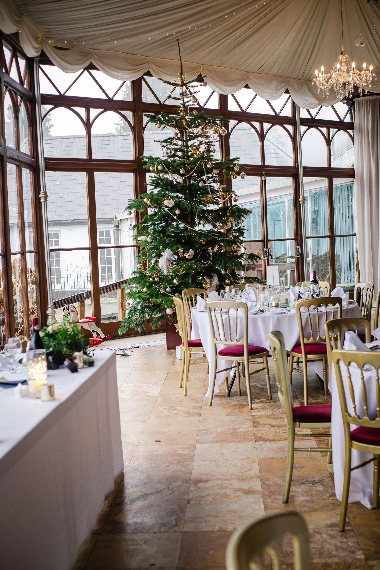 Wedding reception tables arranged inside the Craig y Nos Castle conservatory