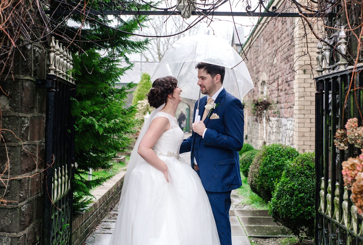 Bride and groom posing beside the stone exterior of Craig y Nos Castle