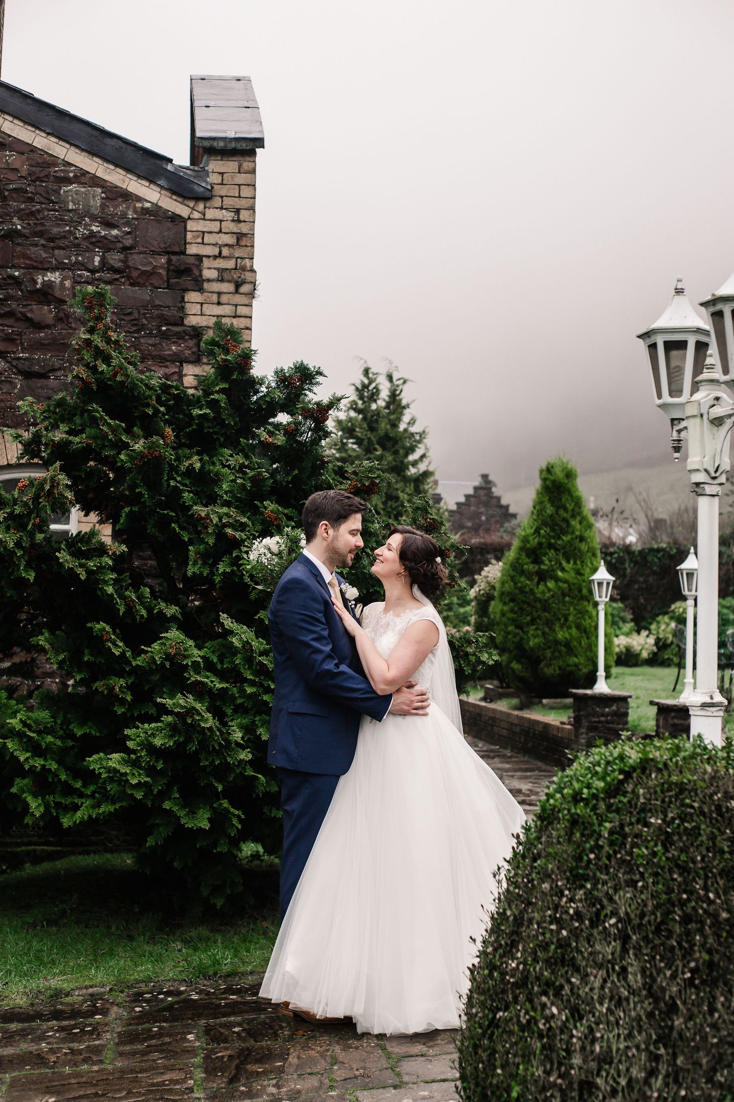 Bride and groom sharing a kiss in the Craig y Nos Castle gardens