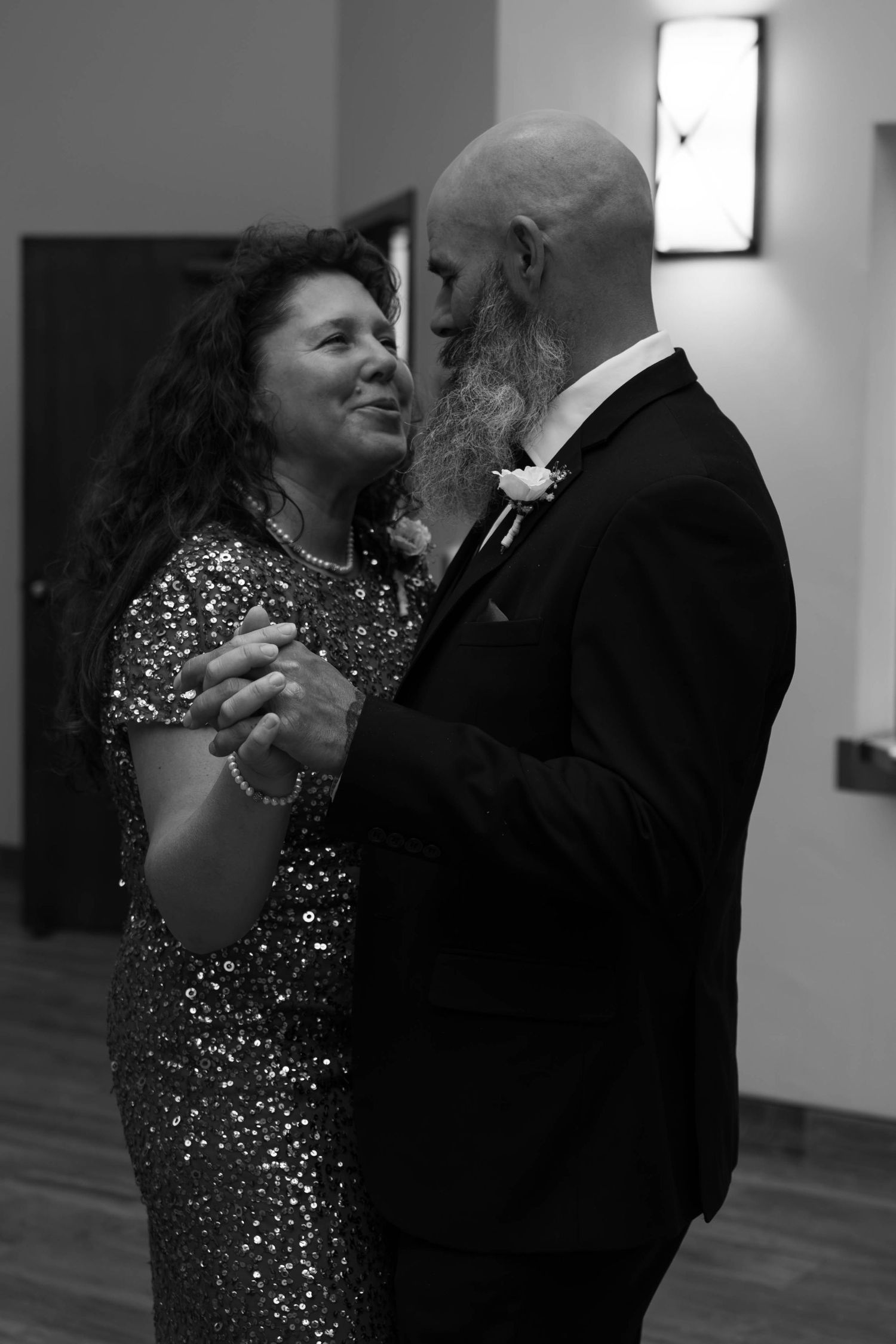 Couple sharing a romantic dance in black and white photo at wedding reception celebration.