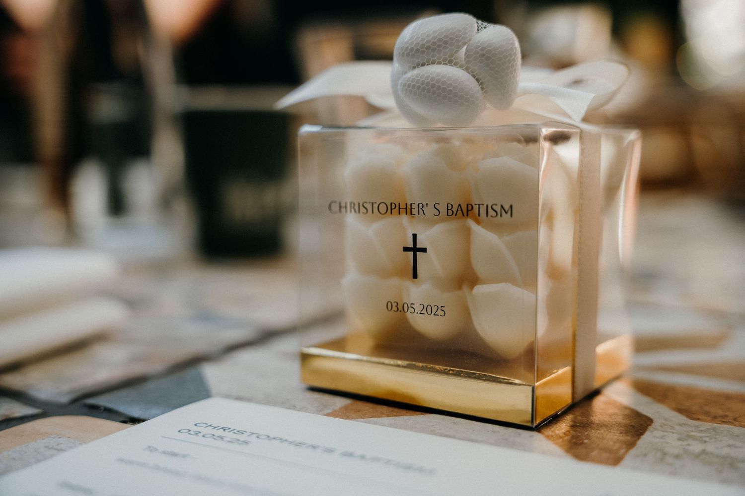 Wedding reception table details with place cards, candles, and elegant decor in warm lighting create an intimate atmosphere.