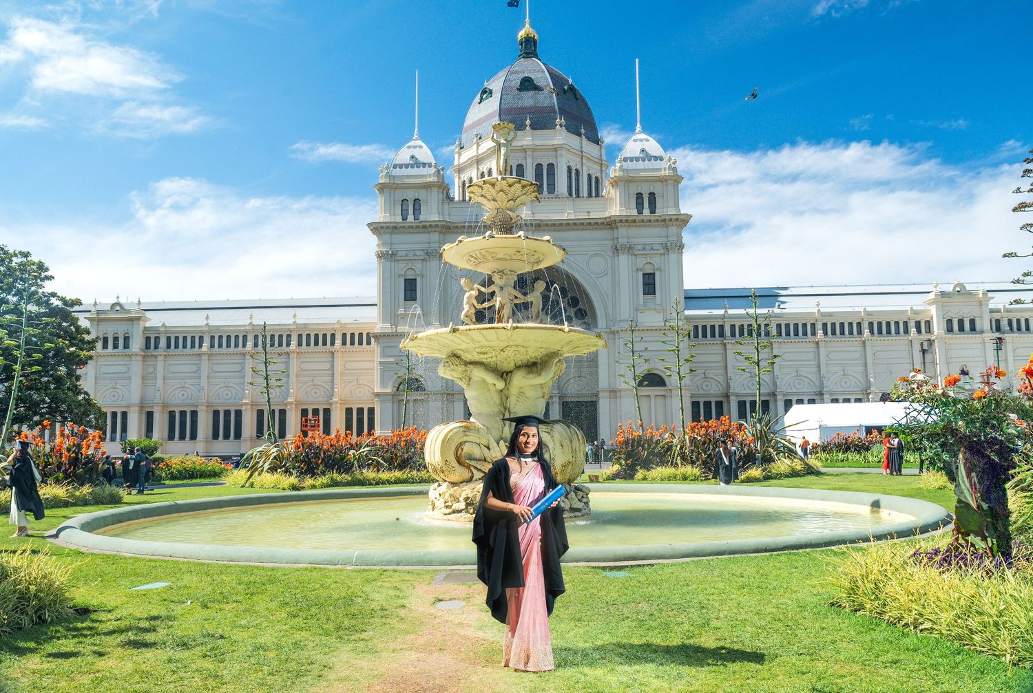A panoramic view of the Royal Exhibition Building in Melbourne with its grand dome and manicured gardens.