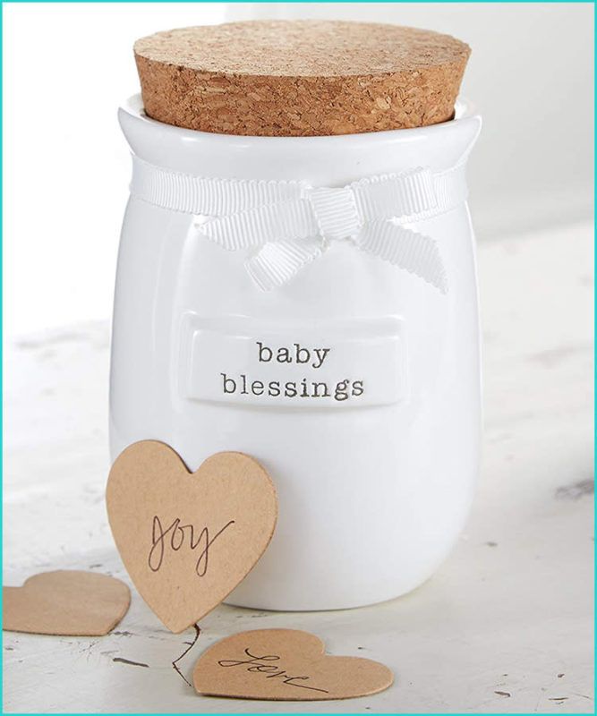 White ceramic jar with cork lid and decorative kraft paper heart tag tied with white ribbon on light surface.