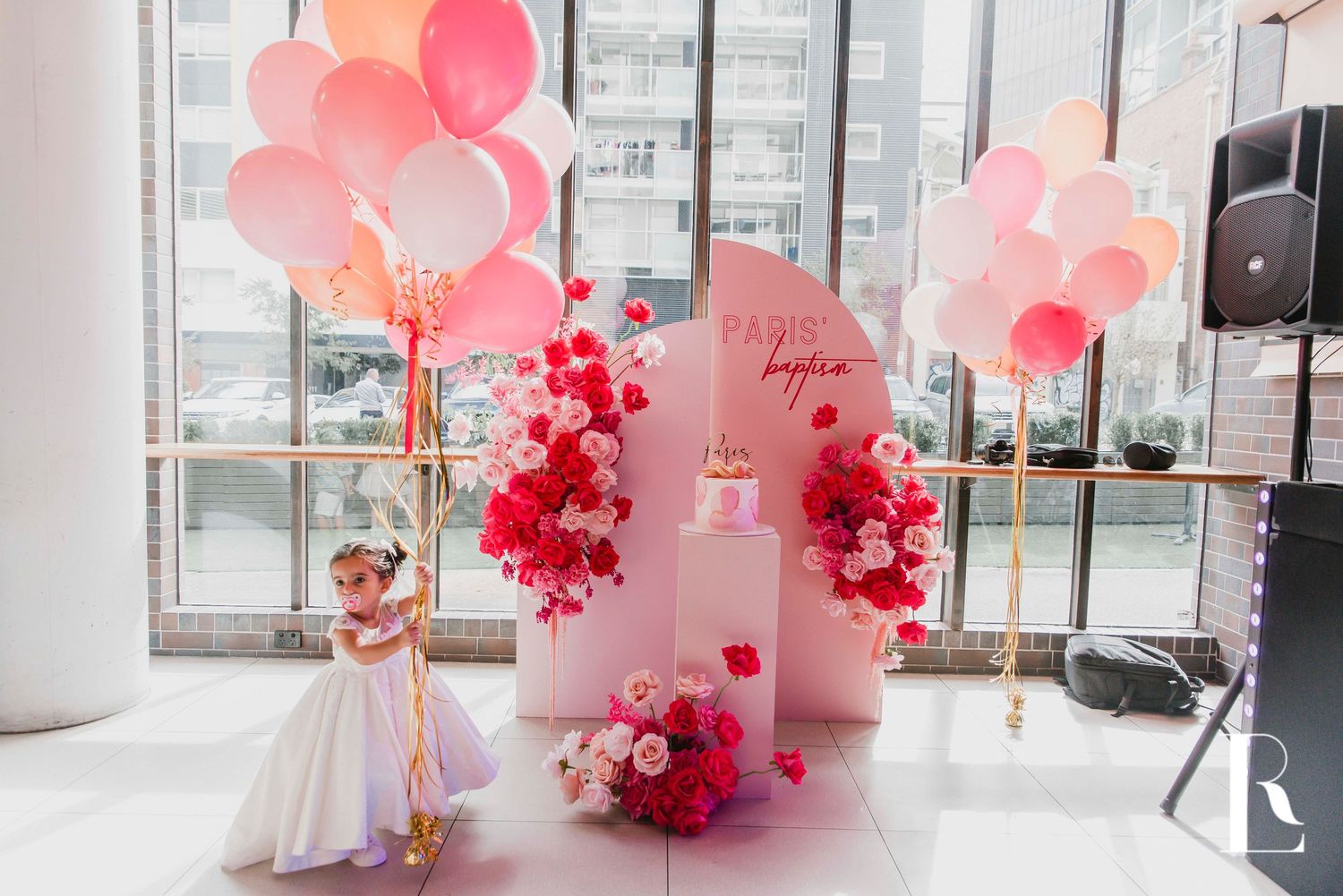Pink and red balloon decorations with heart shapes create a romantic Valentine's Day party atmosphere.