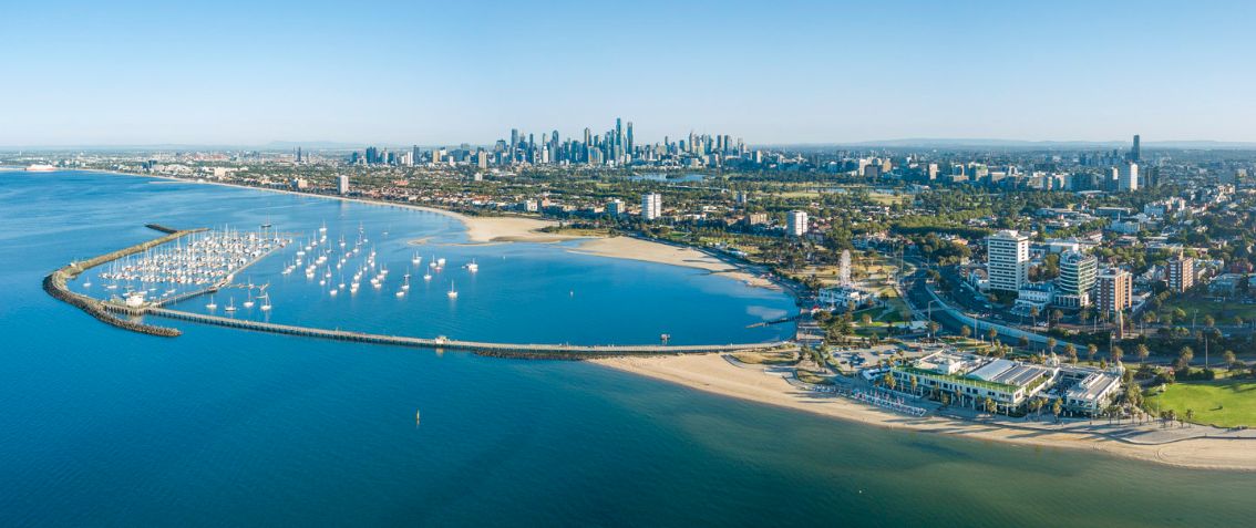Aerial panoramic view of Chicago's skyline and Lake Michigan coastline with boats in harbor on a sunny day.