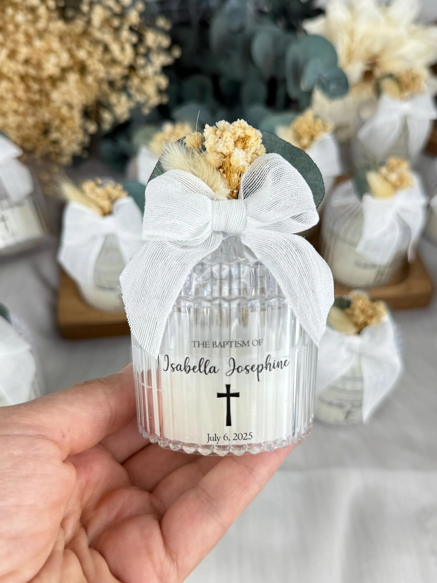 Elegant white paper baptism favors with cross designs and ribbon bows displayed in a series of photos.