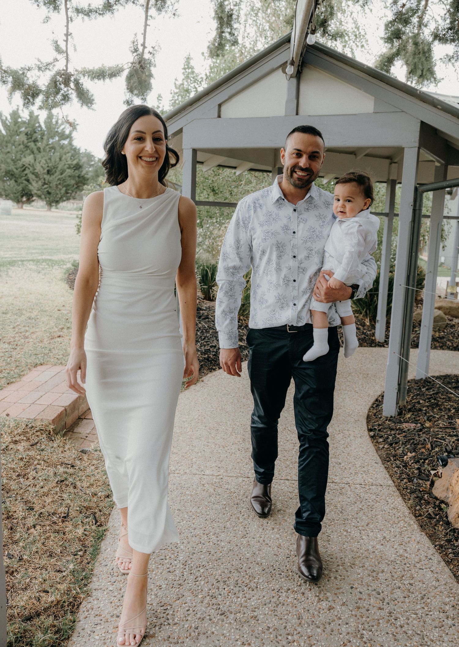 A couple walking together on a gravel path outside a white building, captured in multiple candid moments.
