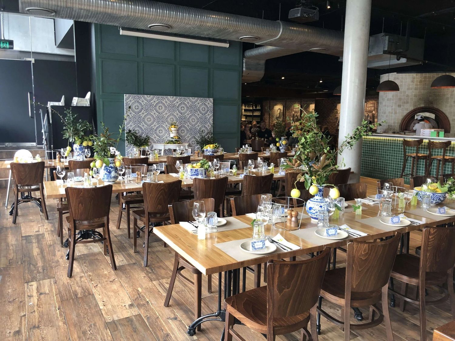 Modern restaurant interior with wooden tables, chairs, and decorative lighting creating a warm, inviting atmosphere.