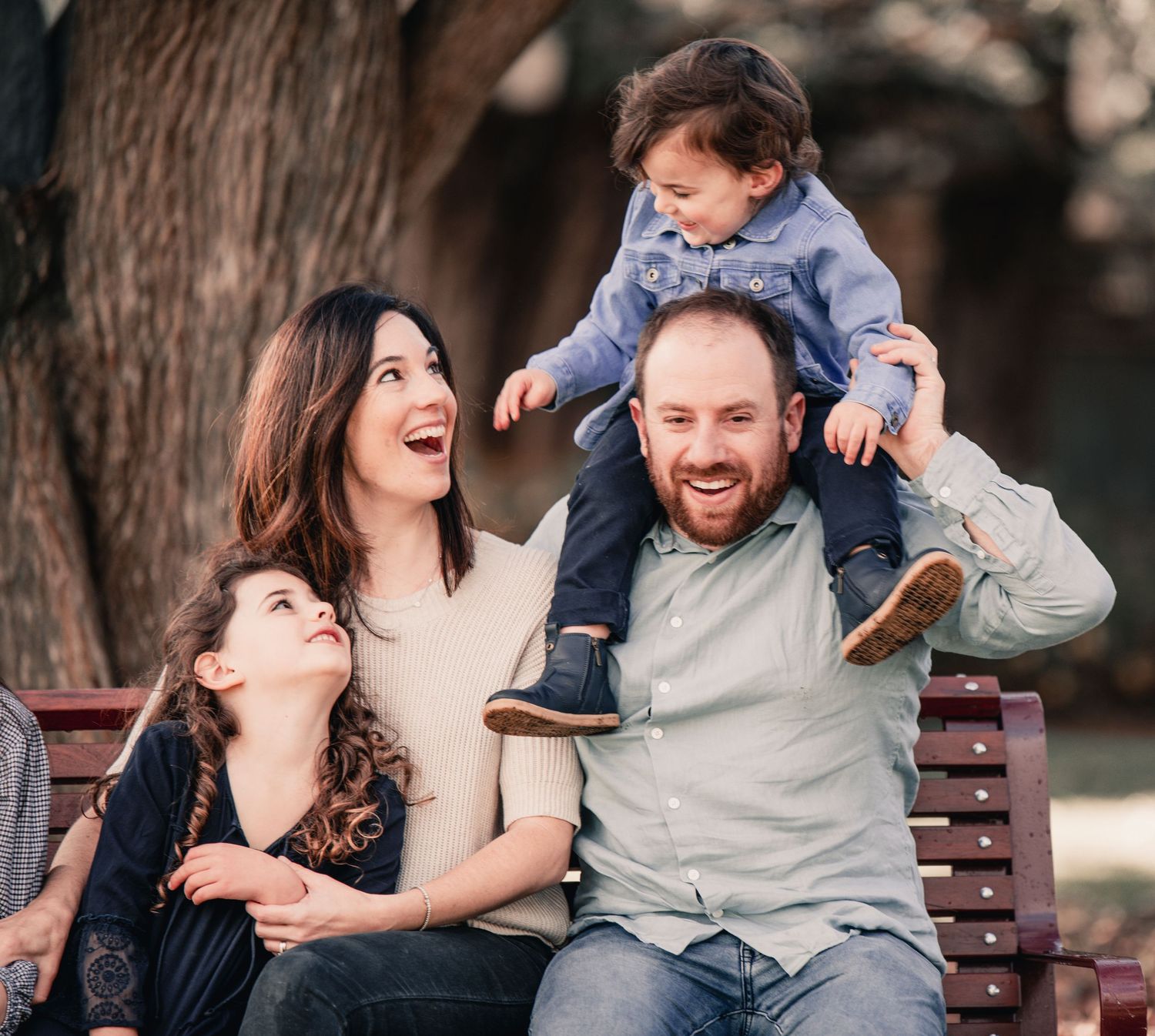 A collage of candid outdoor family photos showing joyful moments and laughter while sitting on a wooden bench.