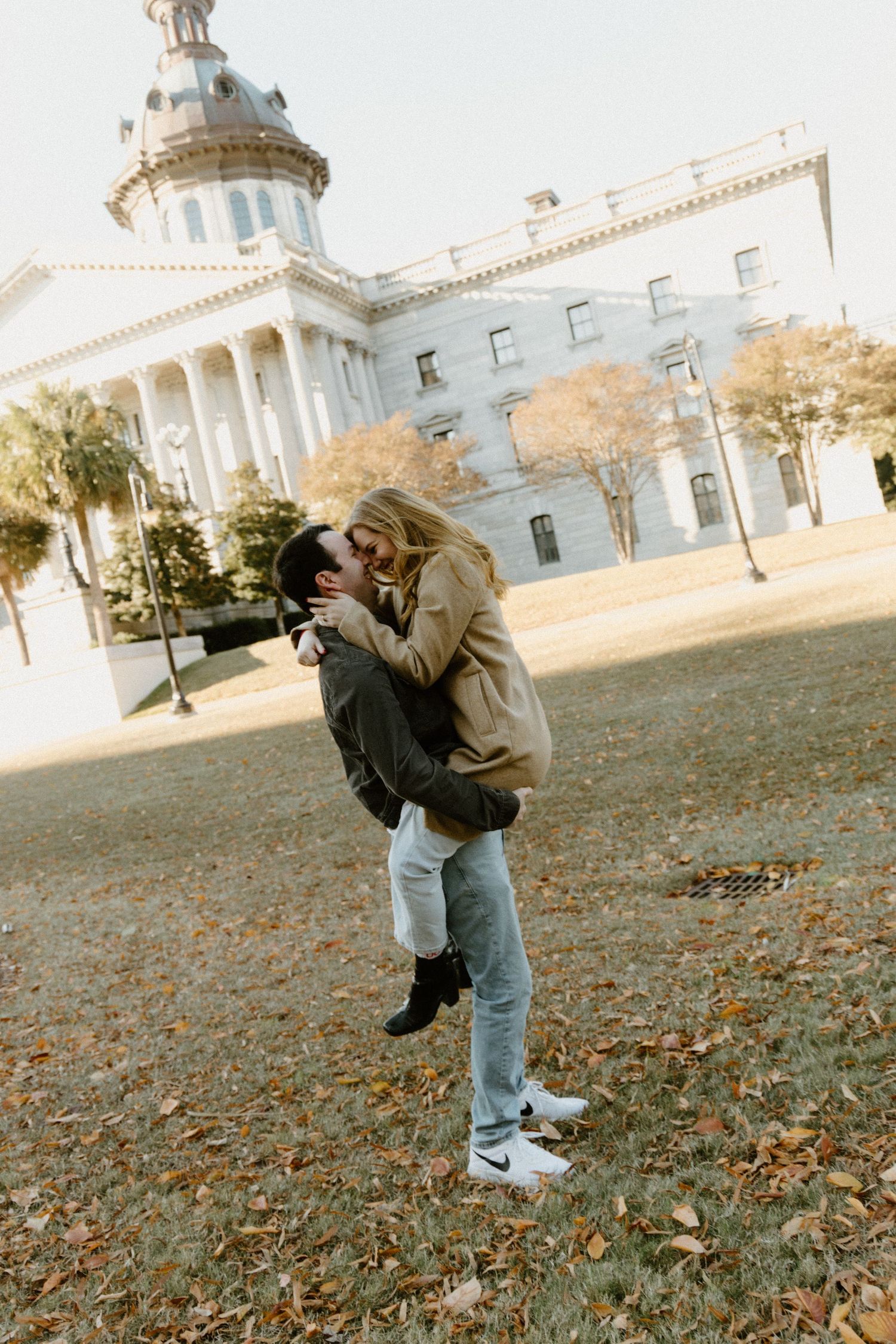Romantic moment captured in front of historic government building with white columns.