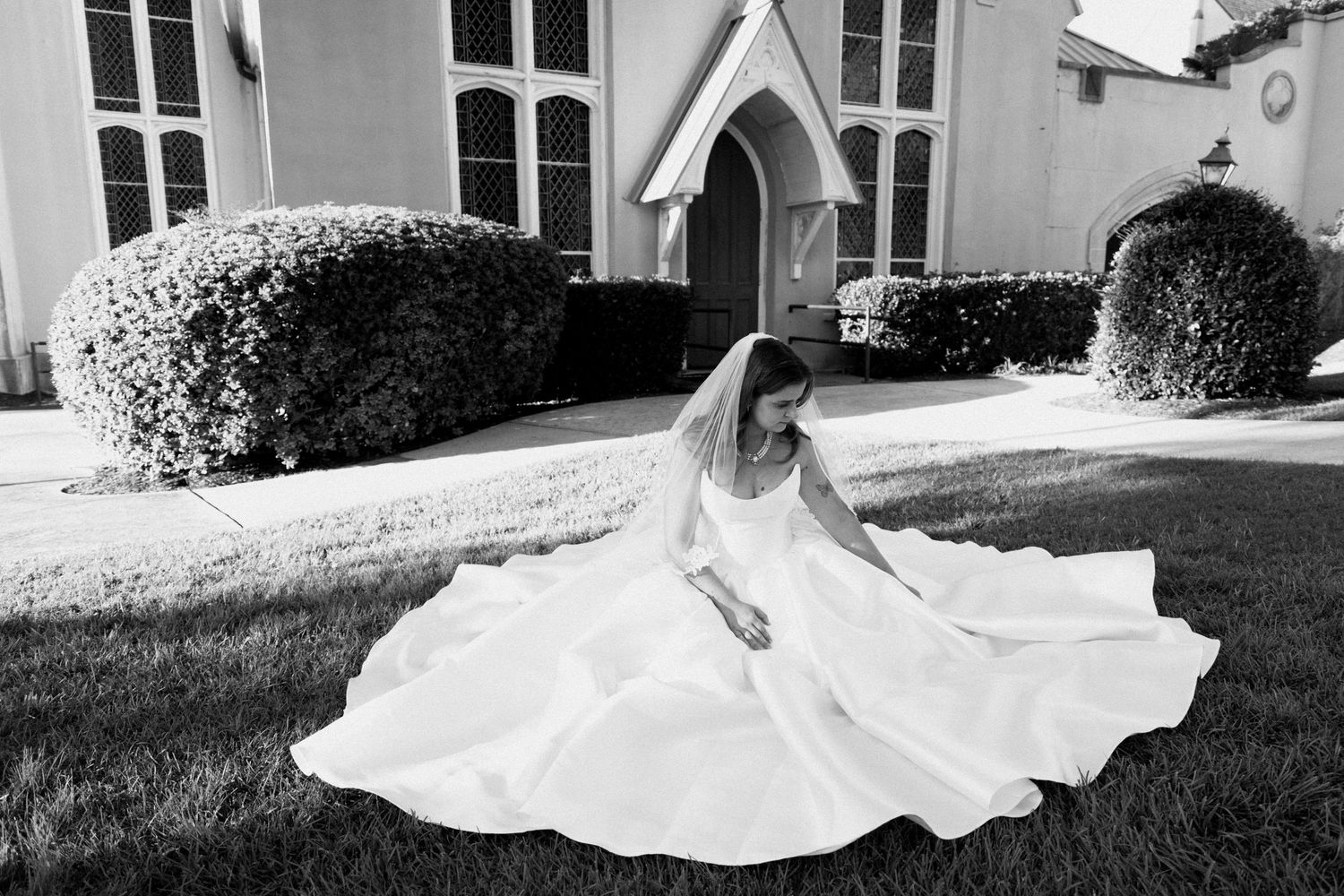 Black and white wedding photos showing bride in flowing dress posing gracefully in garden setting.