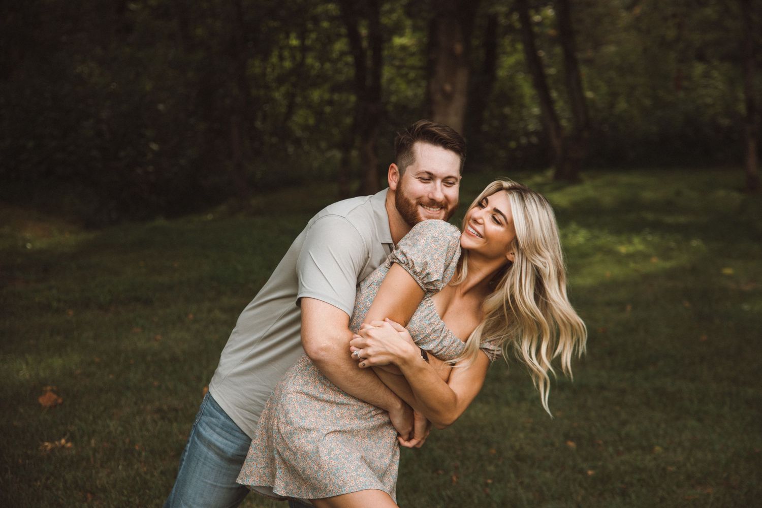 Joyful couple laughing together during outdoor photo session.