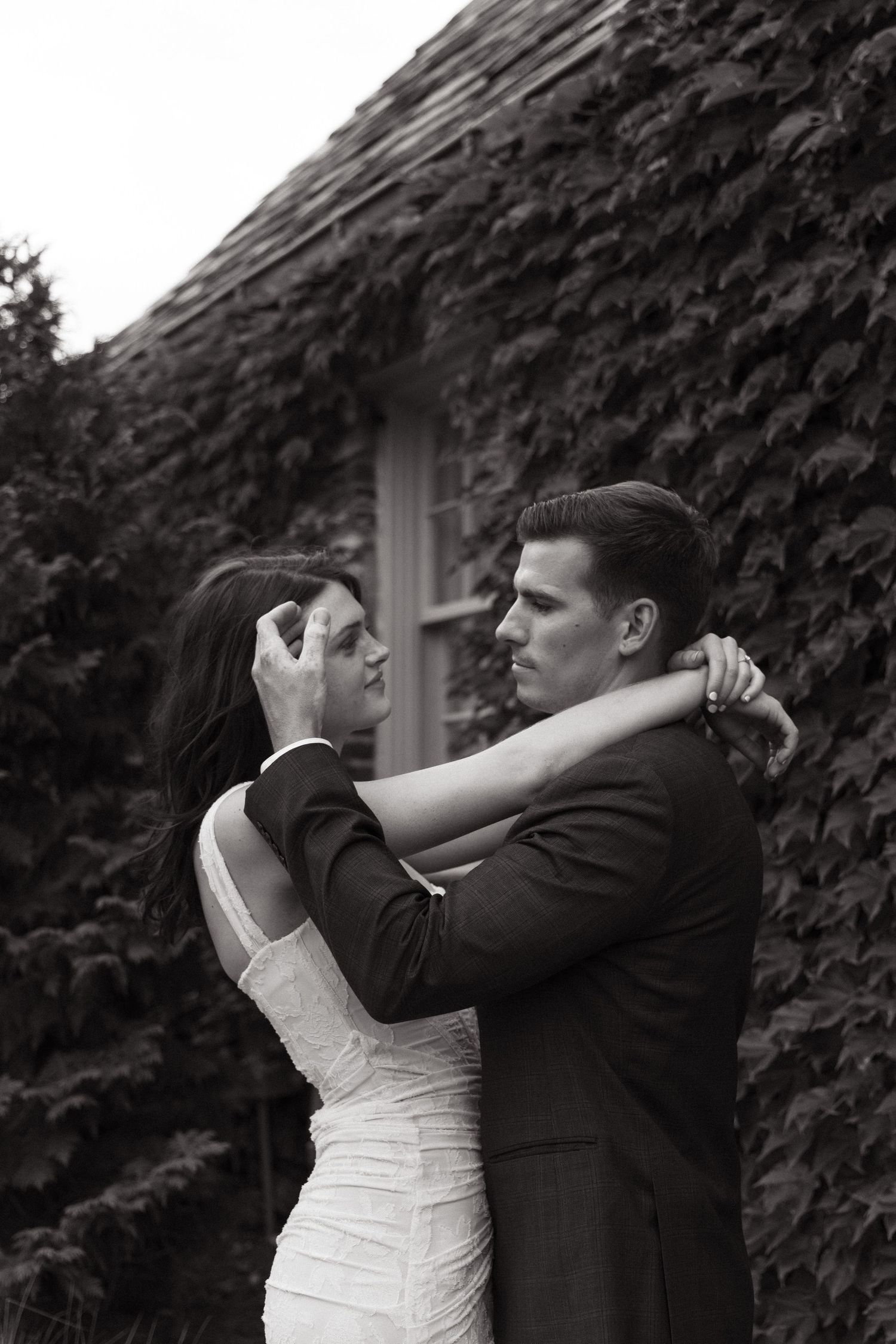 A romantic black and white portrait against an ivy-covered wall.
