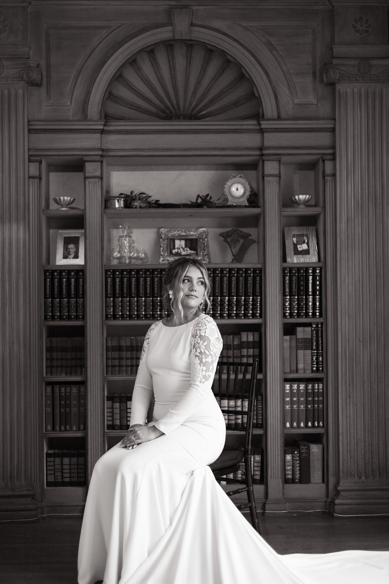 Classic black and white portrait in an elegant library setting.
