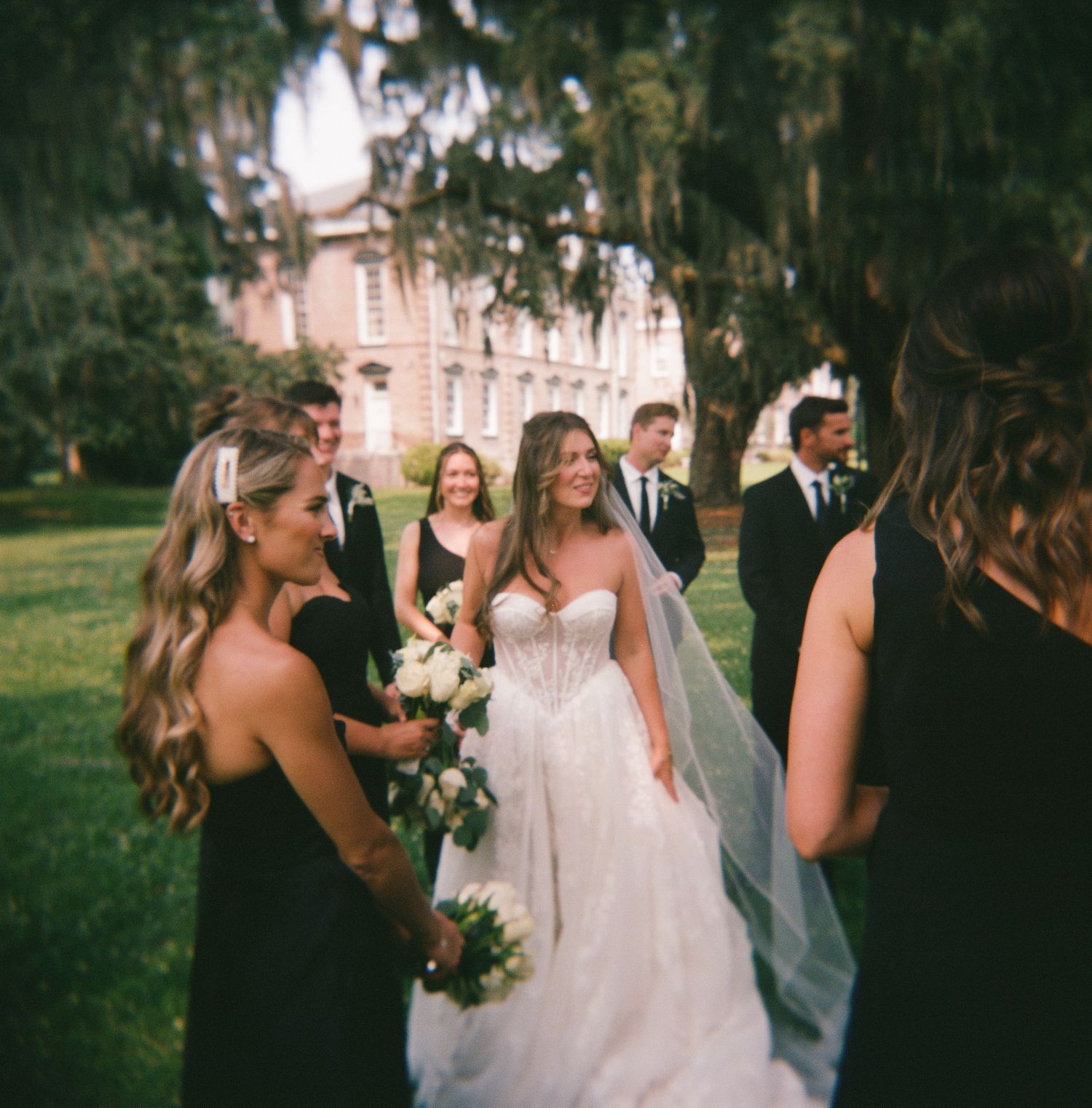 Wedding party laughs and celebrates together during outdoor photo session at sunset.
