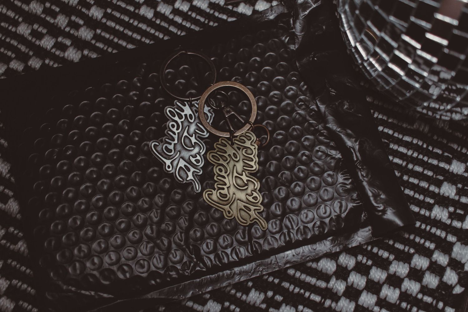 lifestyle product photography, dark, moody, edgy, disco ball, keychain