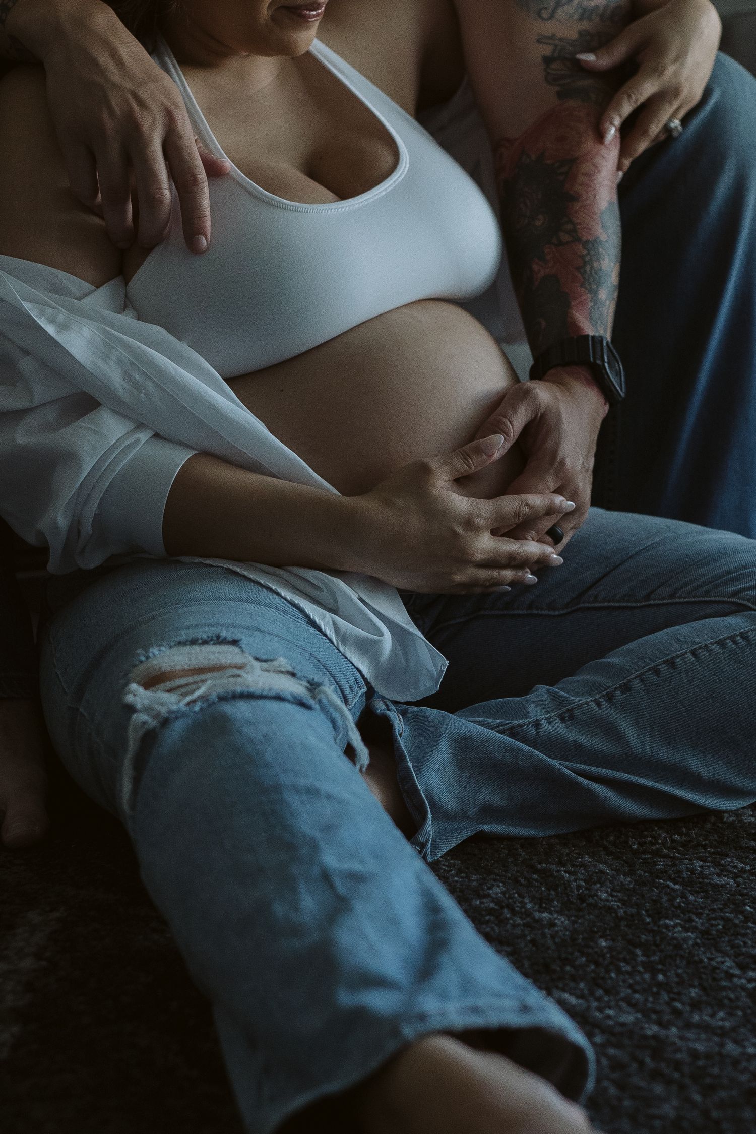 husband and wife holding pregnant belly