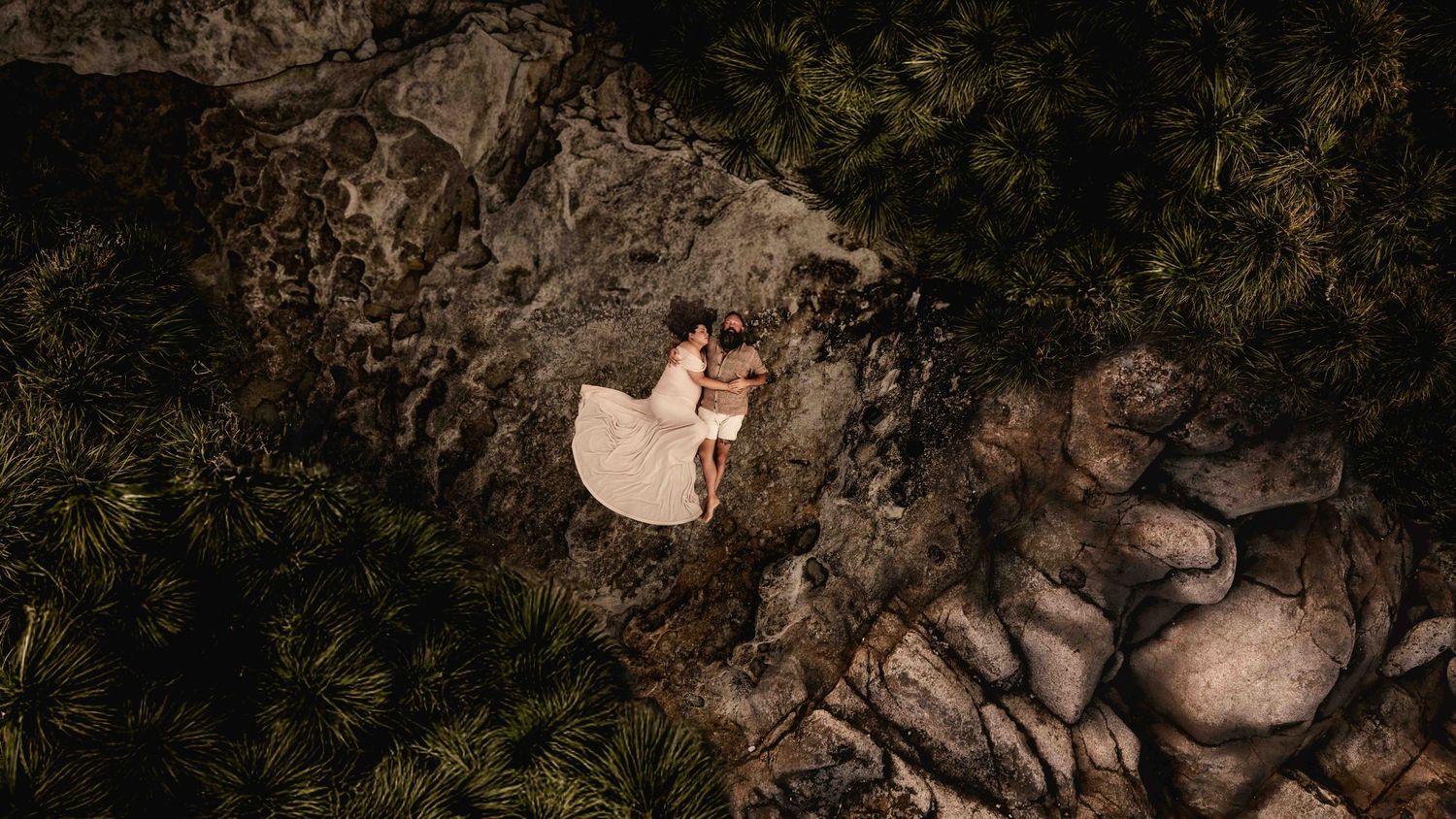 aerial-maternity-drone-photography-couple-laying-together-on-rocks-murrays-beach-jervis-bay