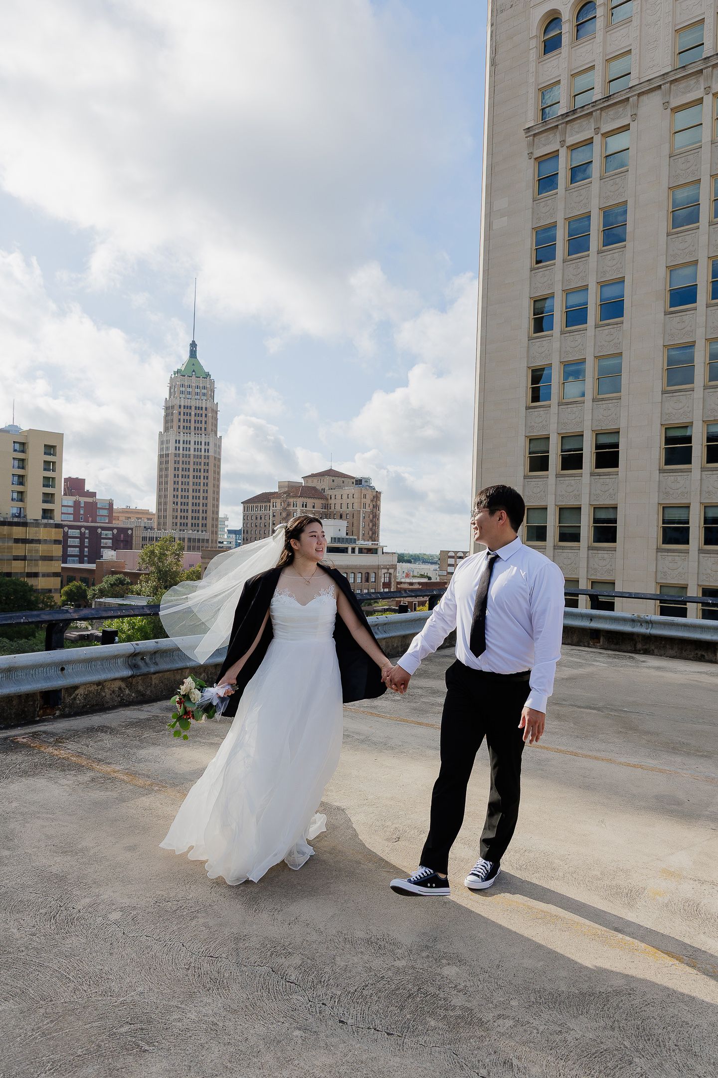 A series of romantic dance poses between a couple on an urban rooftop with city buildings in the background.