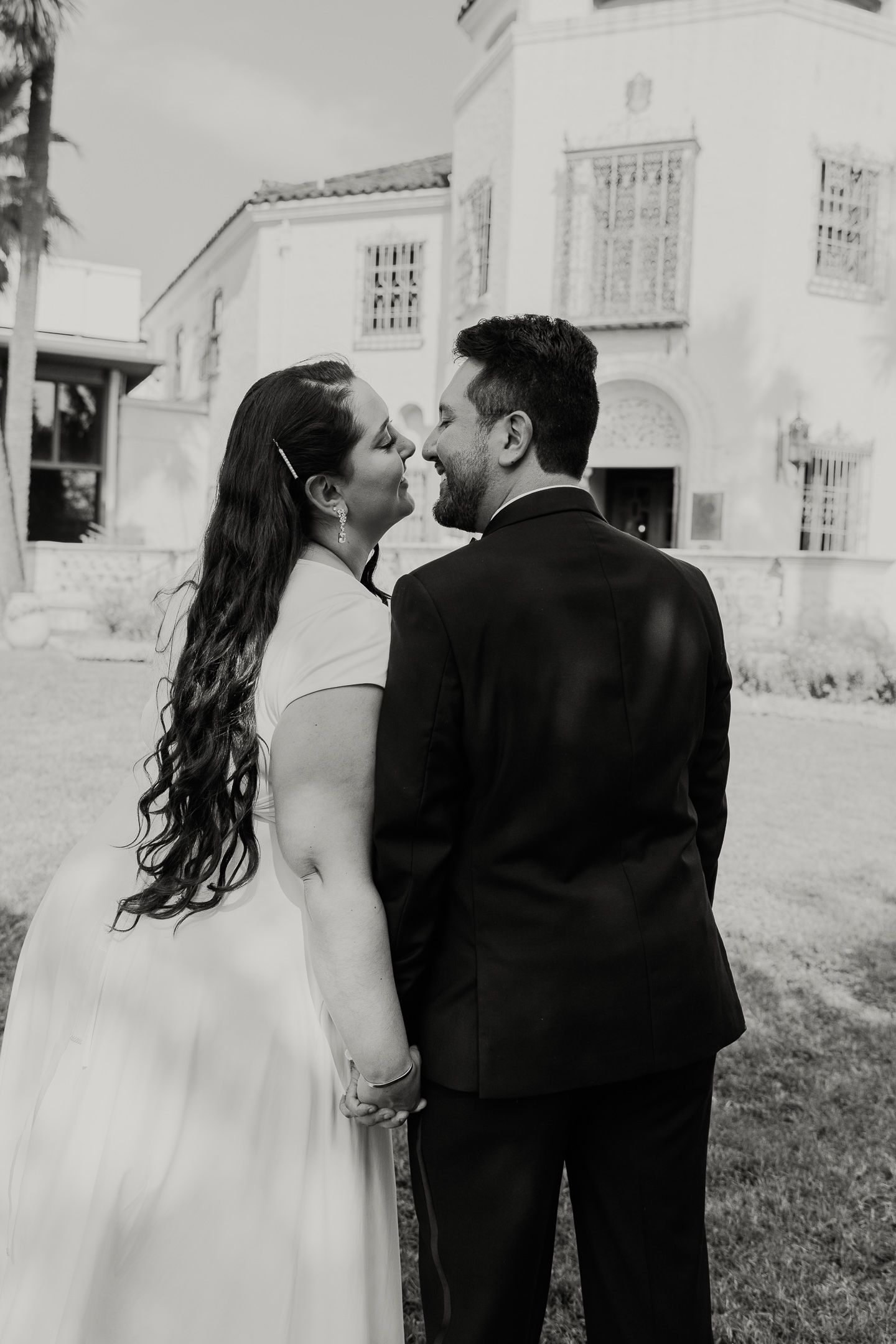 Black and white romantic wedding photos showing intimate kisses between a couple in formal attire.
