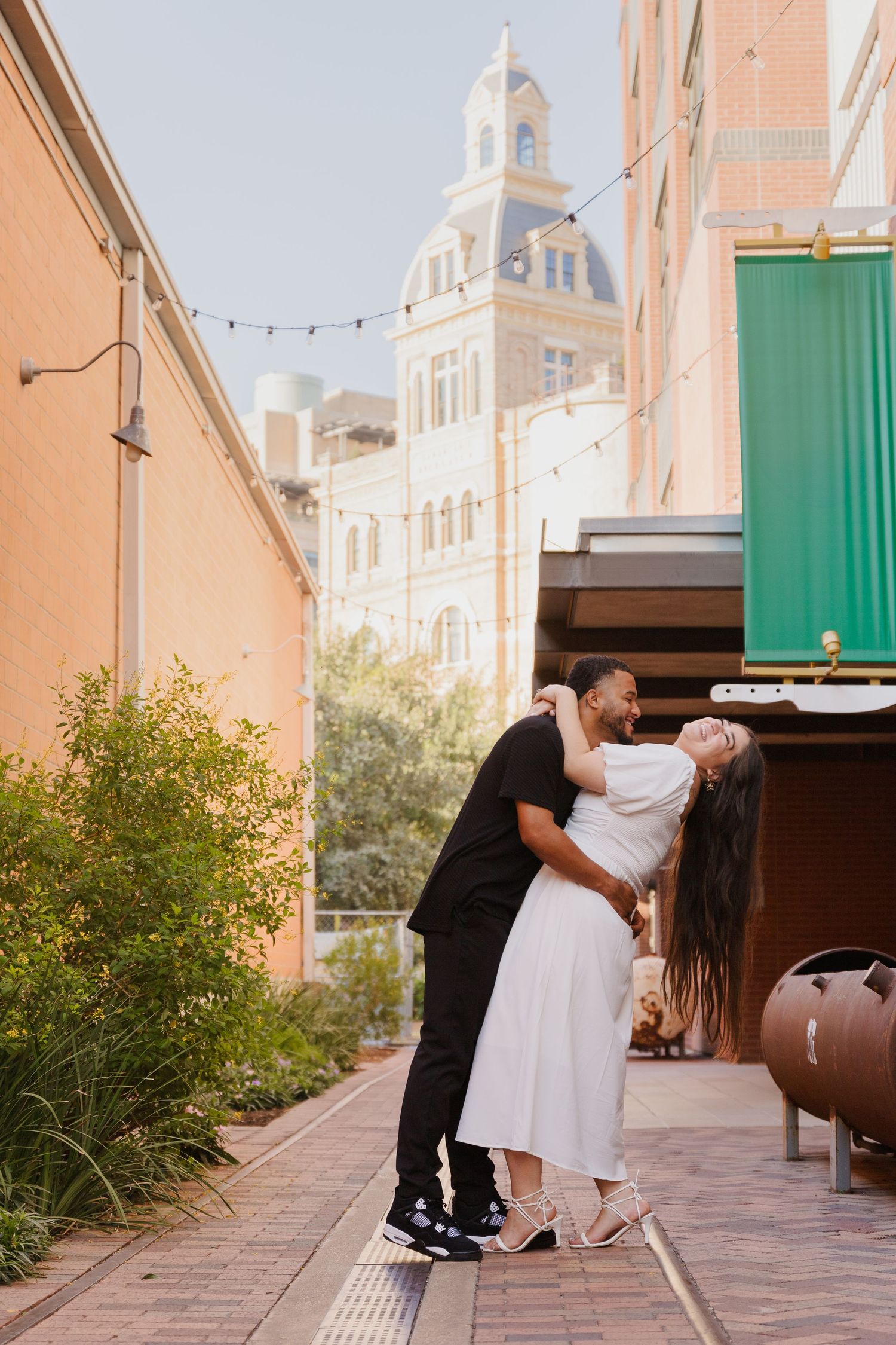 Couple dances on a patio with historic church spire visible in background.