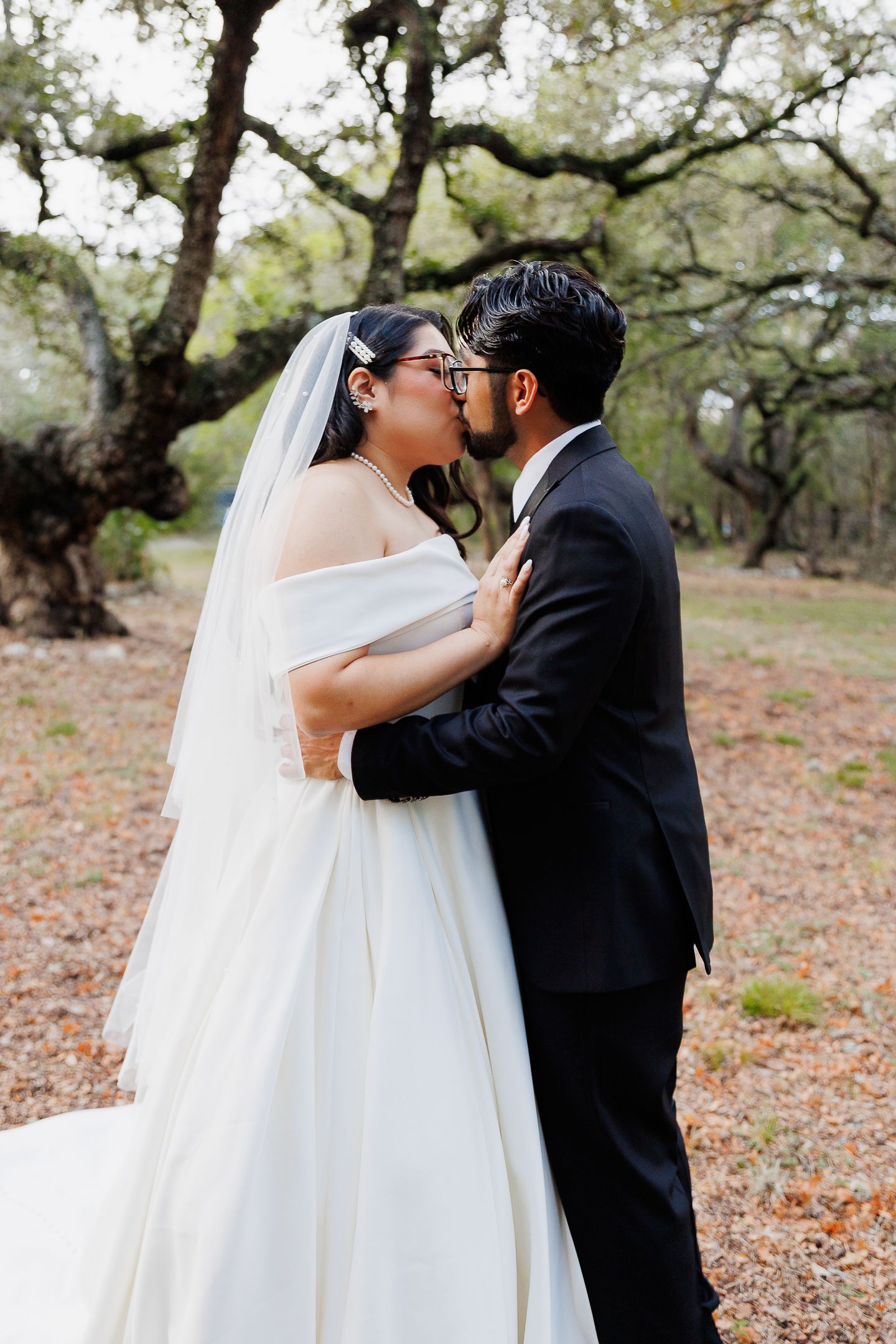 A romantic outdoor wedding moment captured in a series of three photos showing the couple sharing their first kiss.