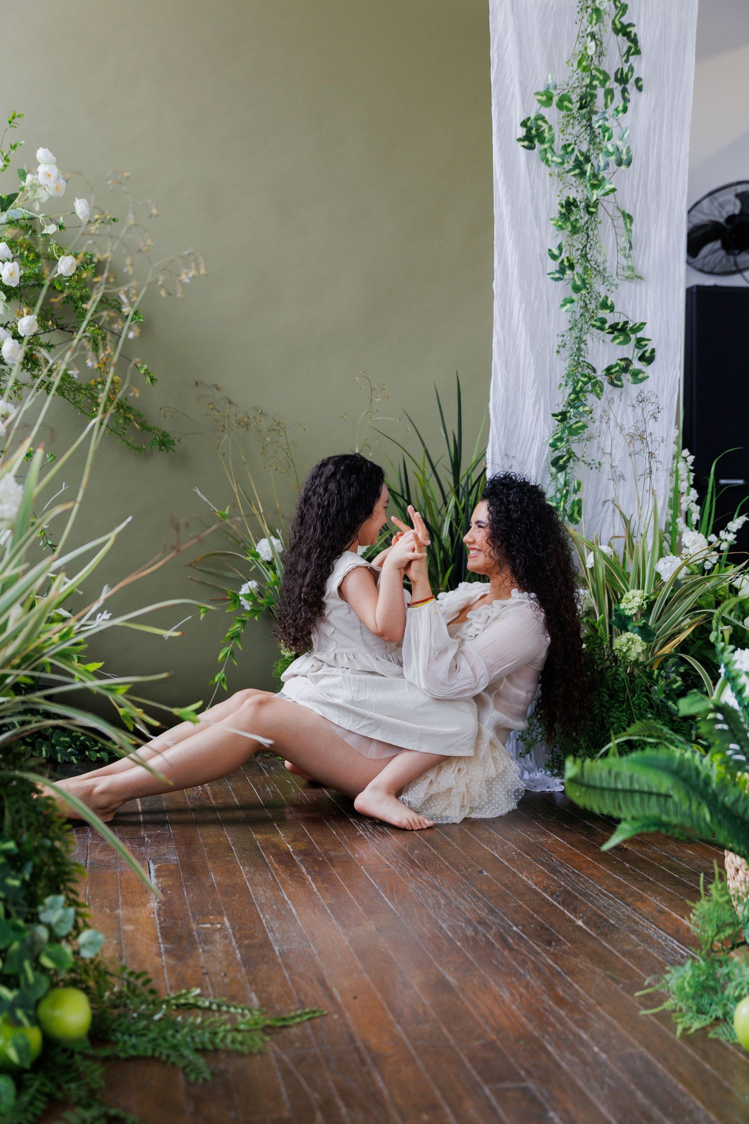 Artistic photo series showing a person in white dress reclining on wooden floor surrounded by green plants and natural light.