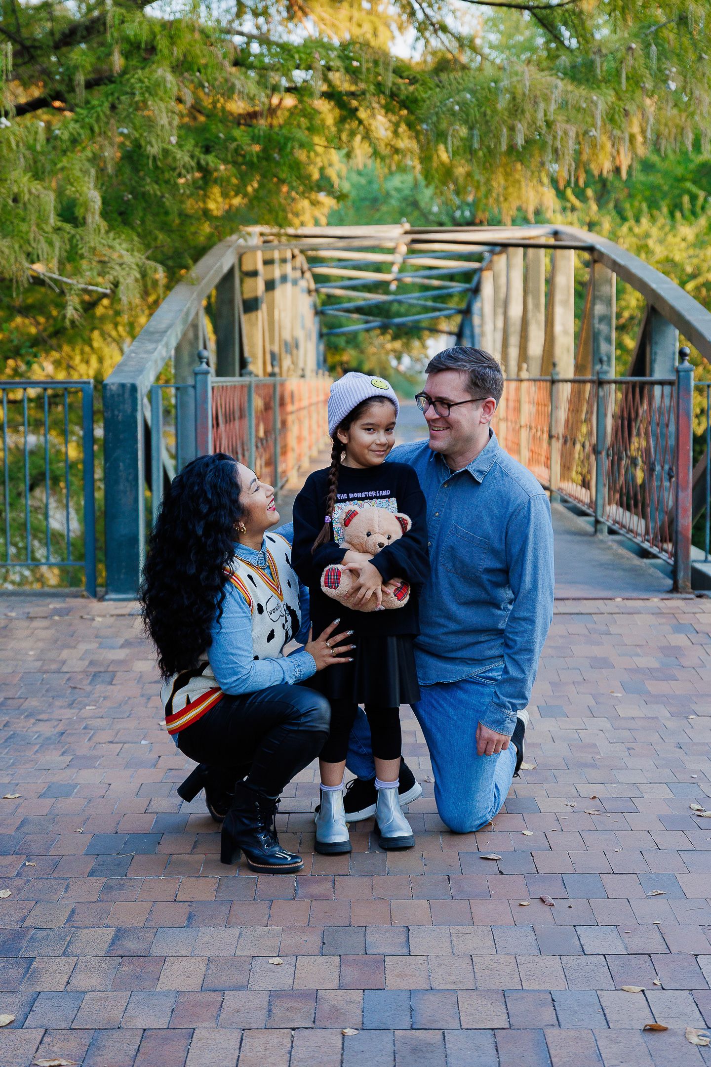 A couple shares tender moments on a brick walkway surrounded by autumn trees.