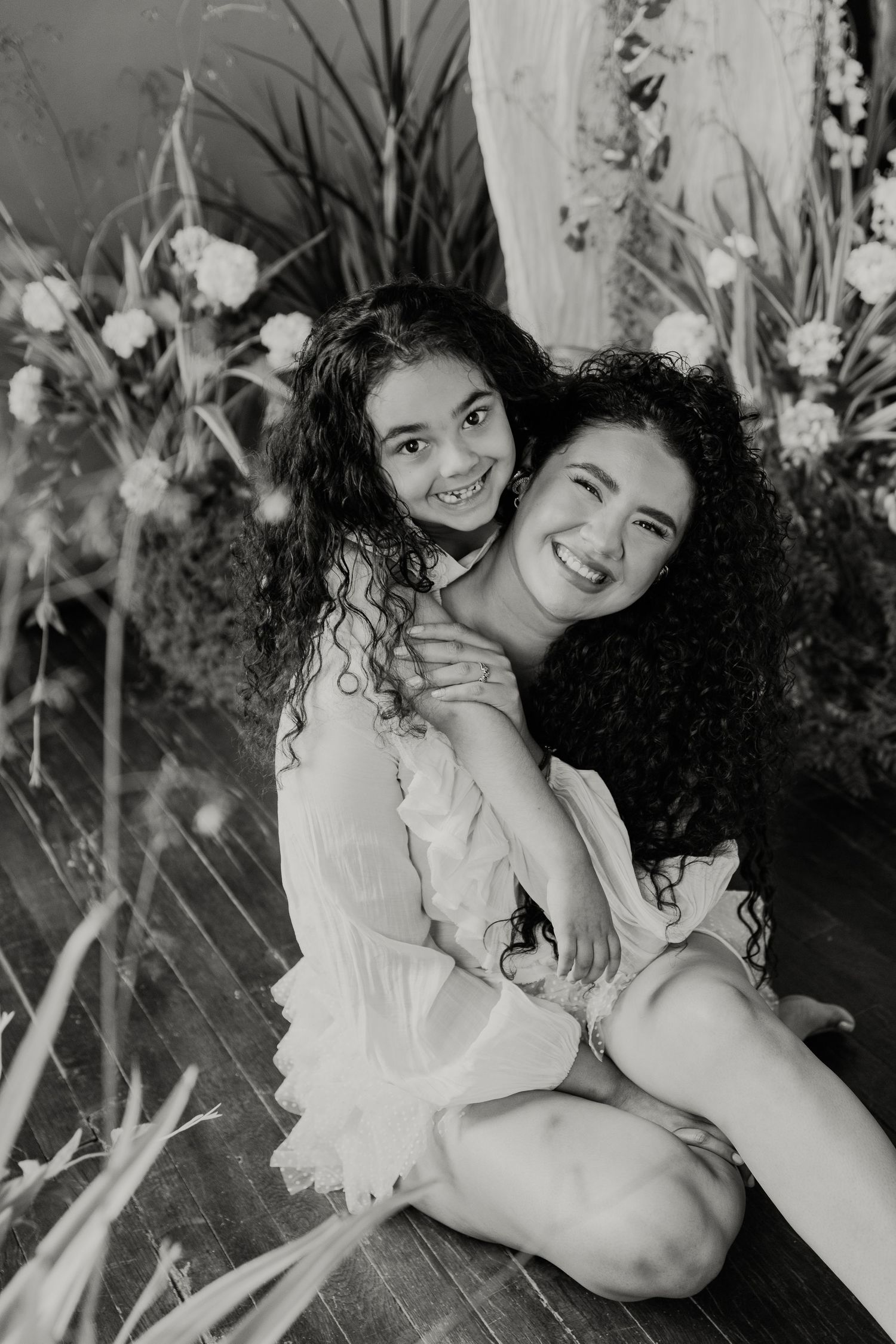 Black and white romantic photo series showing intimate moments between two people in a garden setting.