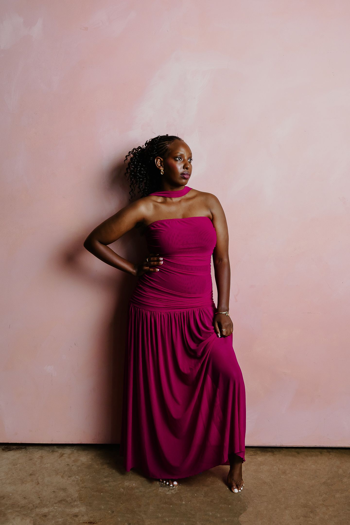 Series of artistic portraits showing a woman in a burgundy dress posing against a pink wall.
