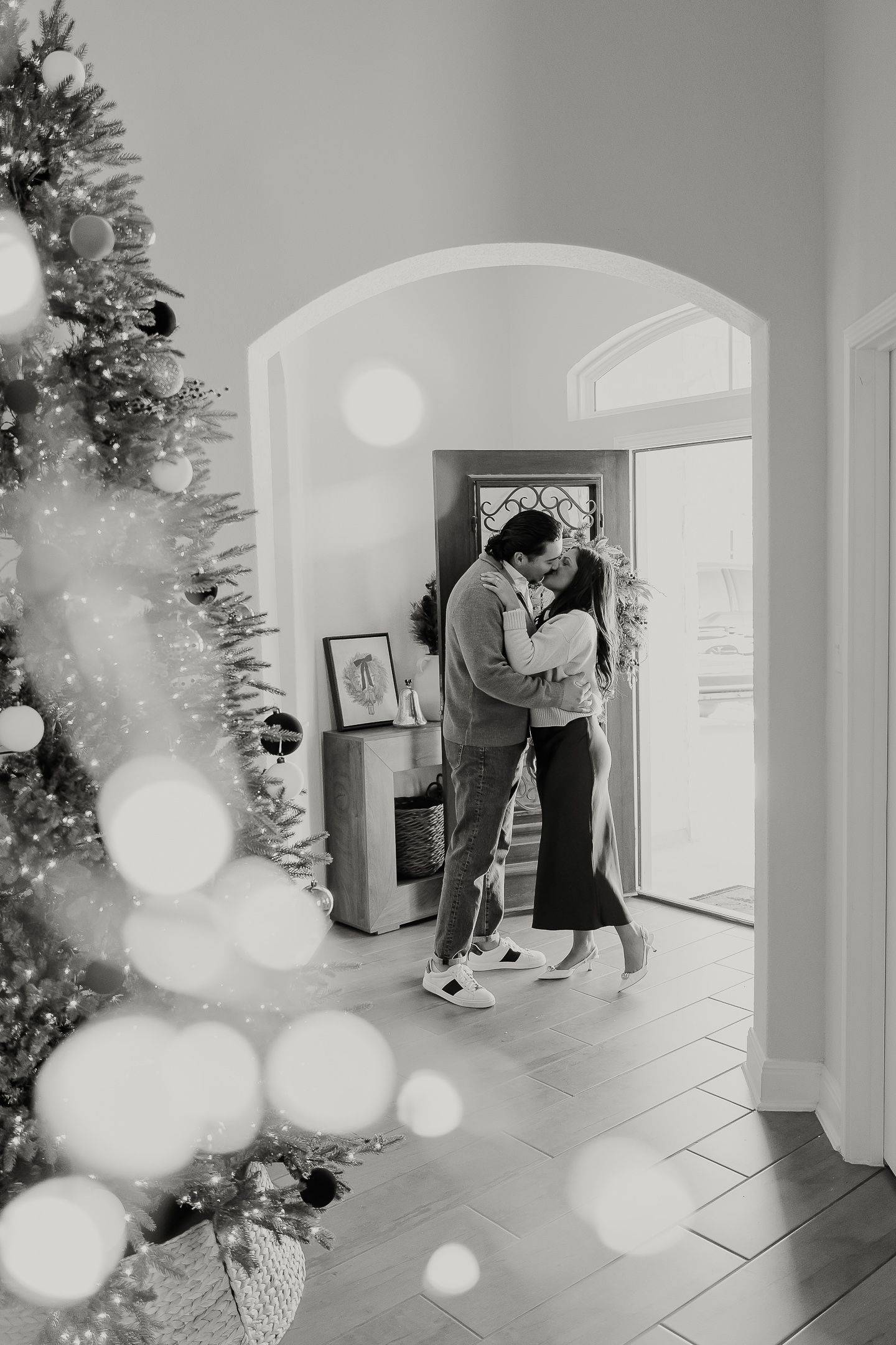 A black and white photo sequence showing two figures dancing in an arched hallway with bokeh light effects.