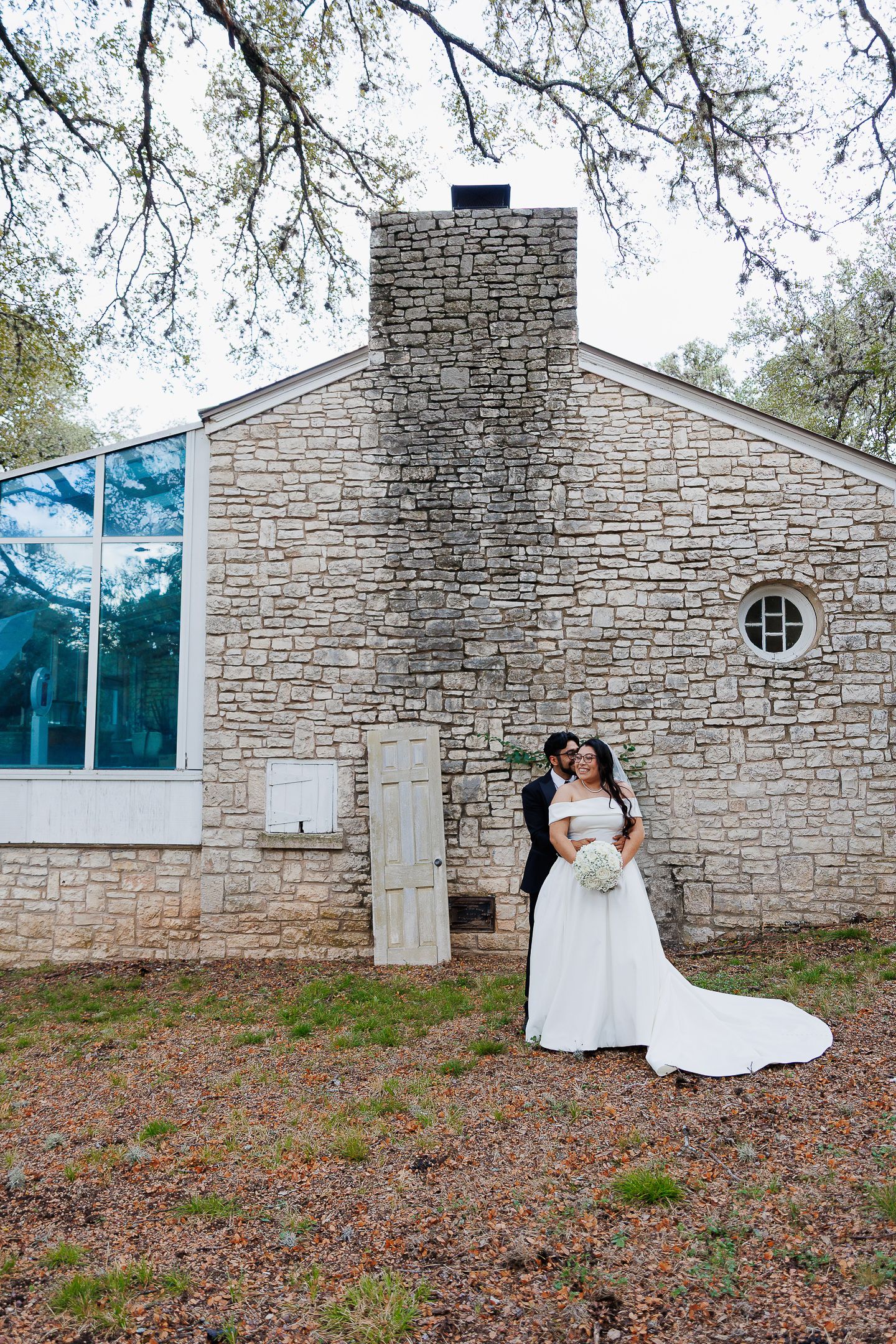 A series of progressive shots showing figures in white dresses against a modern stone chapel wall in a natural setting.