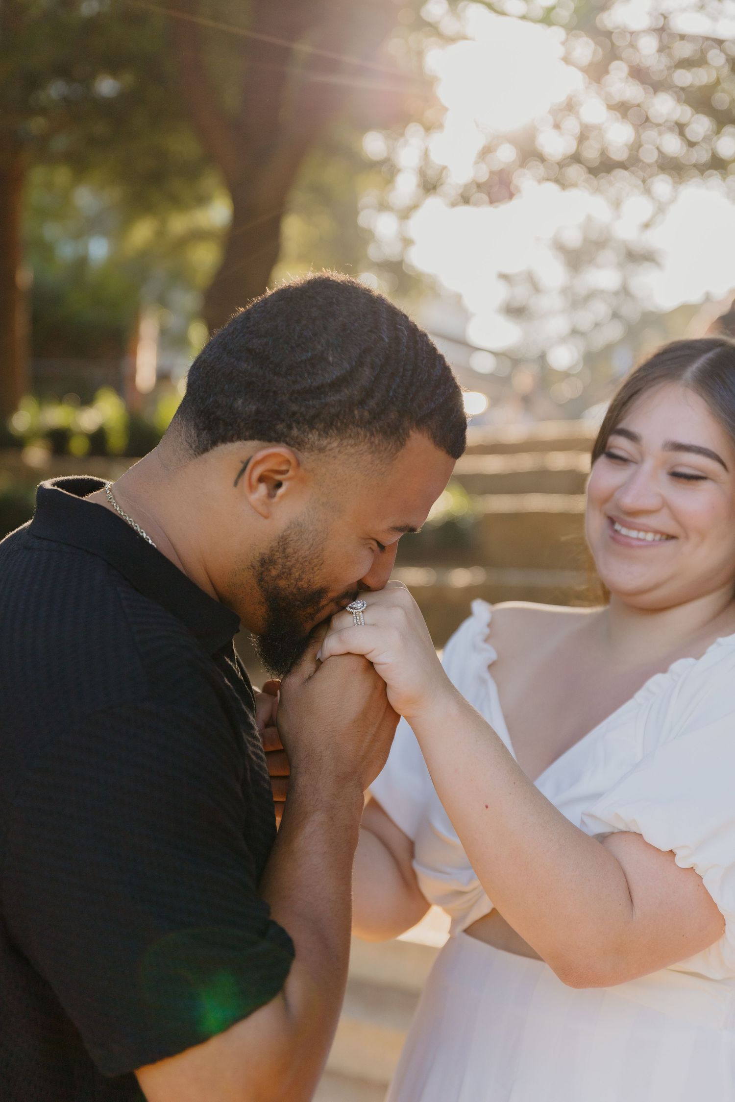 A sweet moment shared between a couple in warm sunset lighting outdoors.