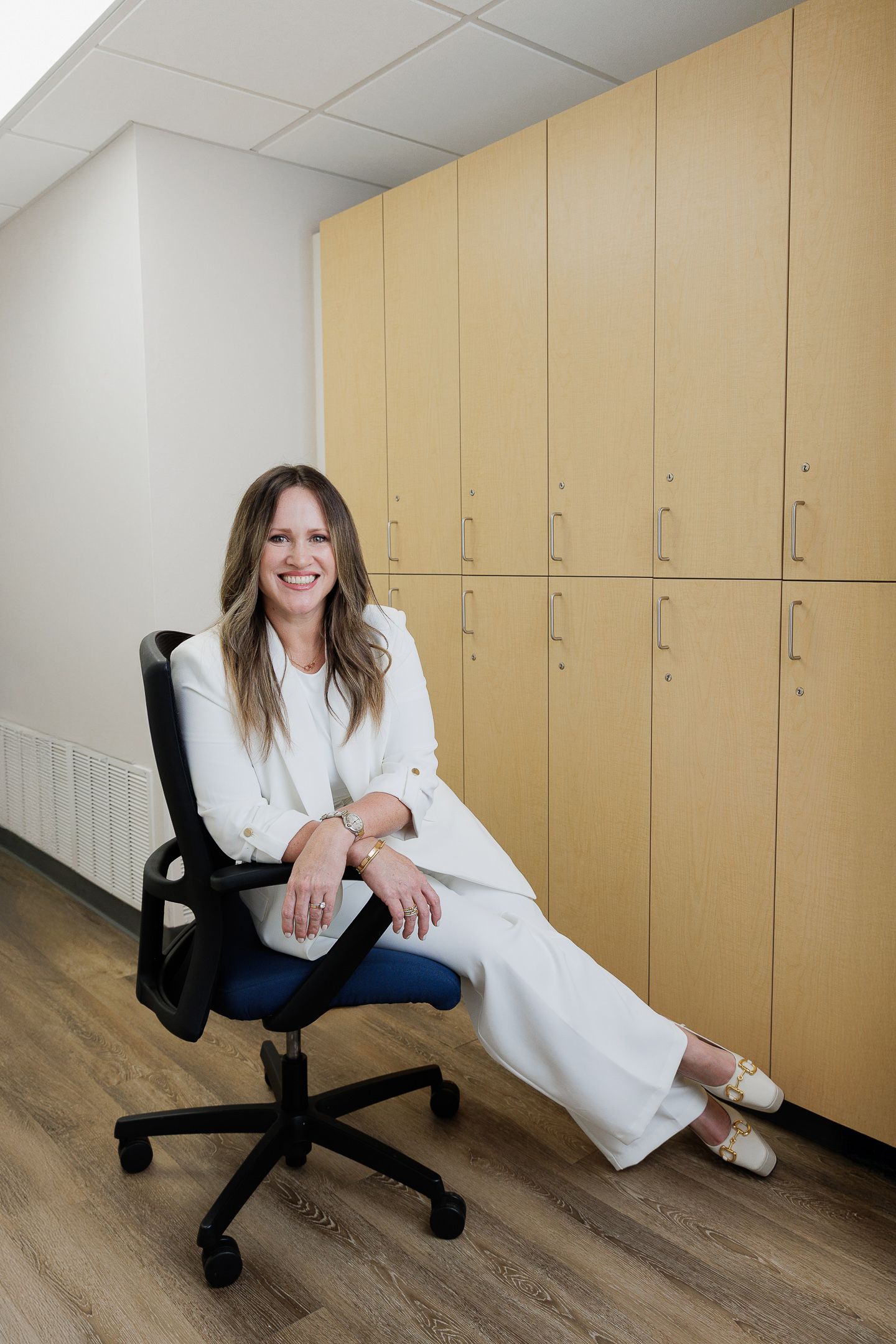 A series of photos showing someone in a white lab coat sitting on an office chair against wooden lockers in a room.