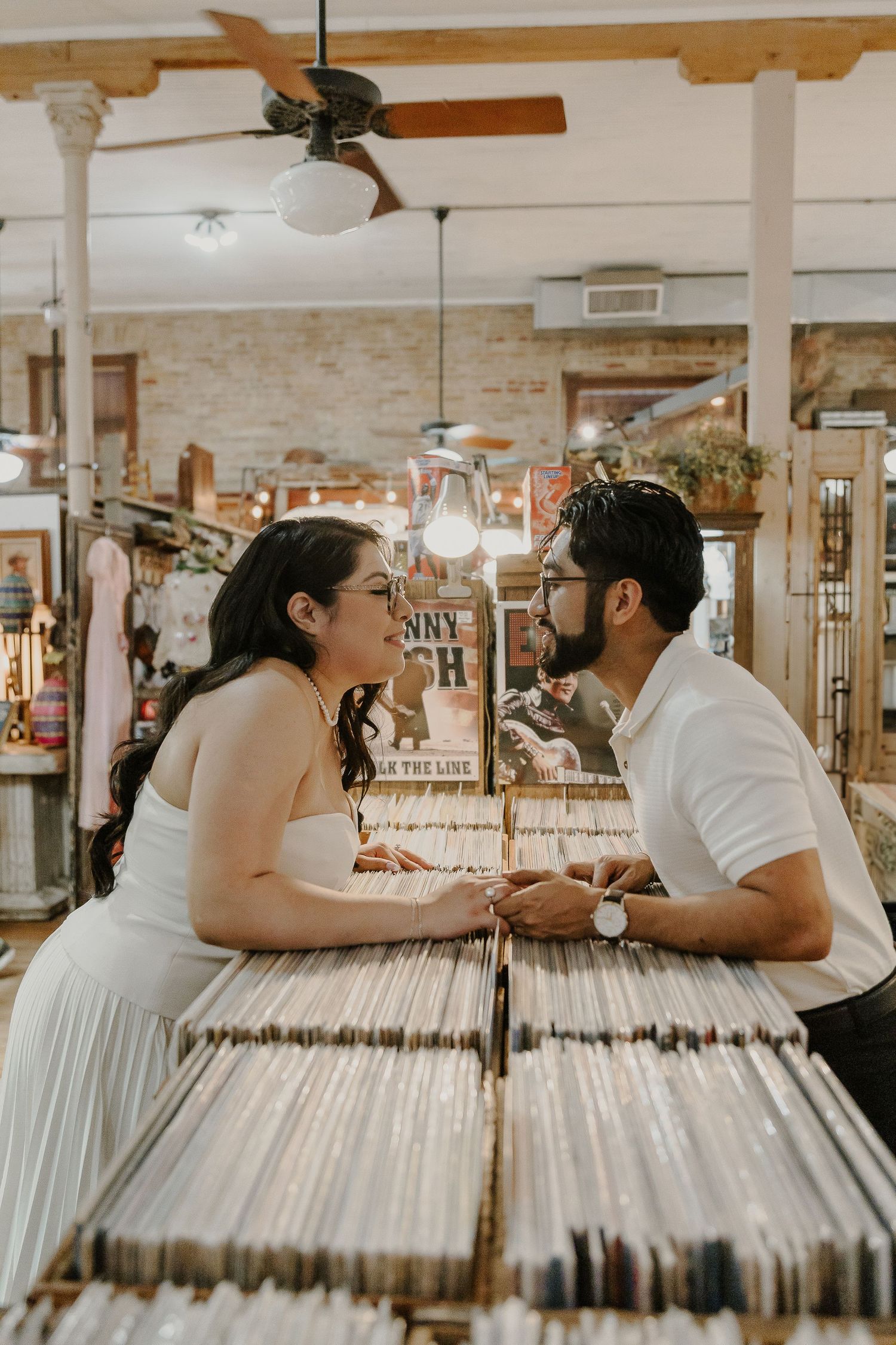 Couple leans across record store bins for romantic moment.
