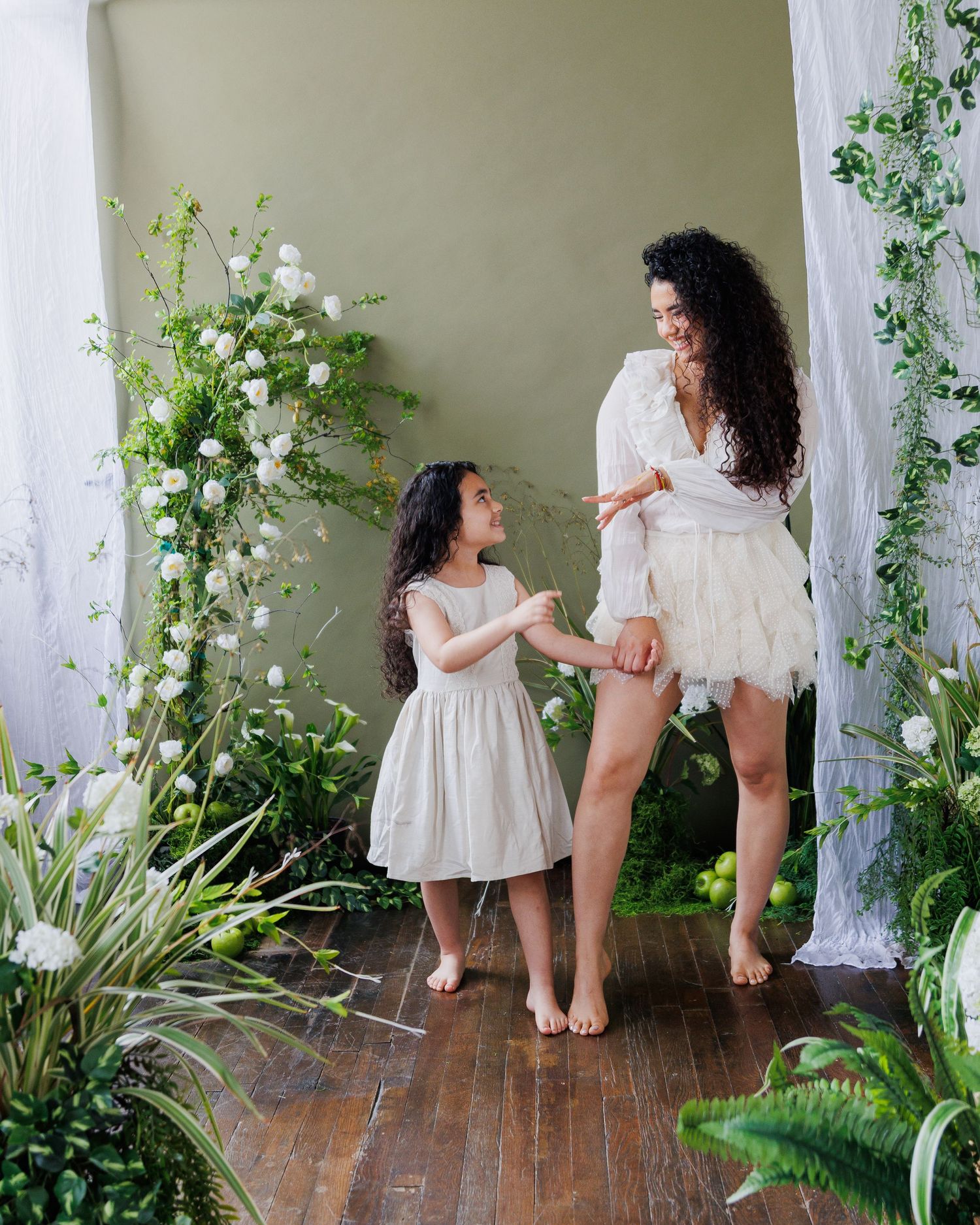 A series of four artistic photos showing a romantic scene with white dresses and climbing vines in an indoor setting.