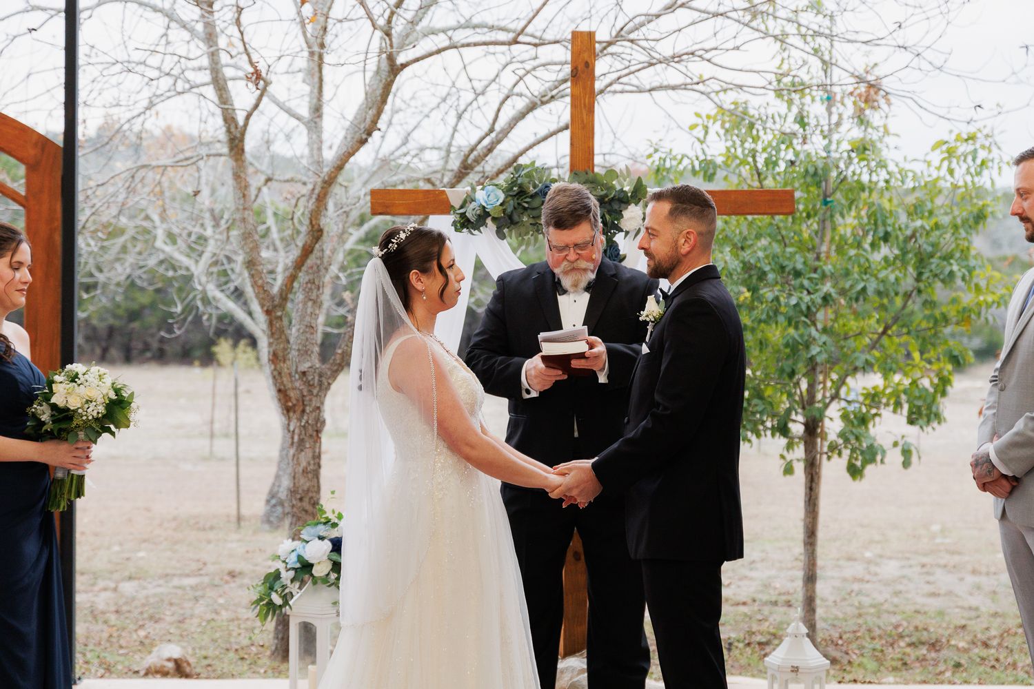 Wedding party gathered outdoors under bare winter trees during an intimate ceremony celebration.