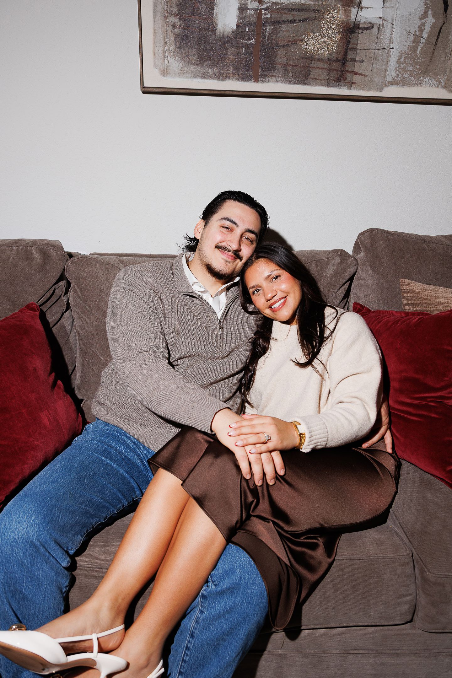 A sequence of candid moments showing a couple relaxing together on a gray couch.