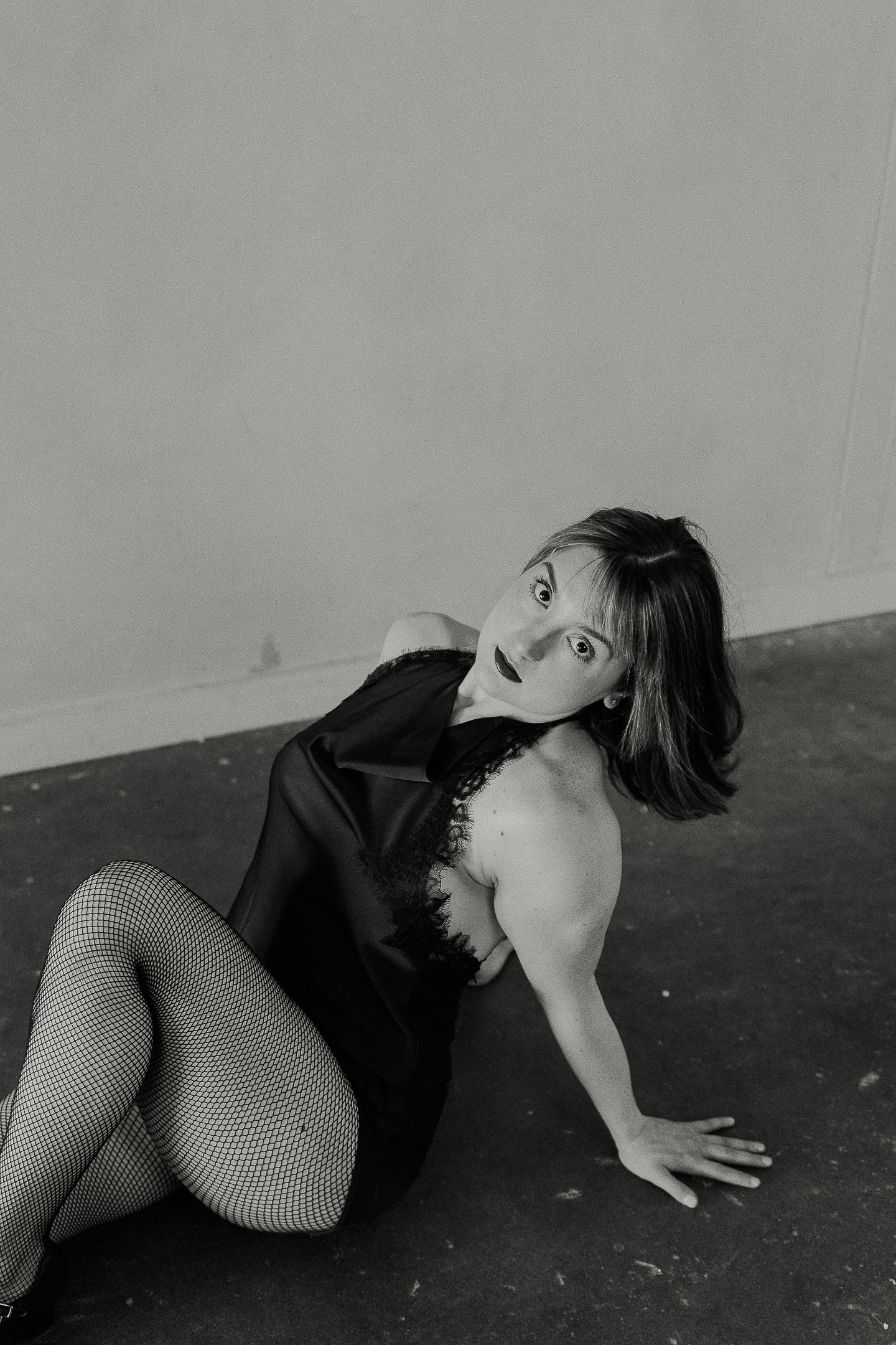 A series of black and white artistic photographs showing a person in dramatic poses against a dark floor.