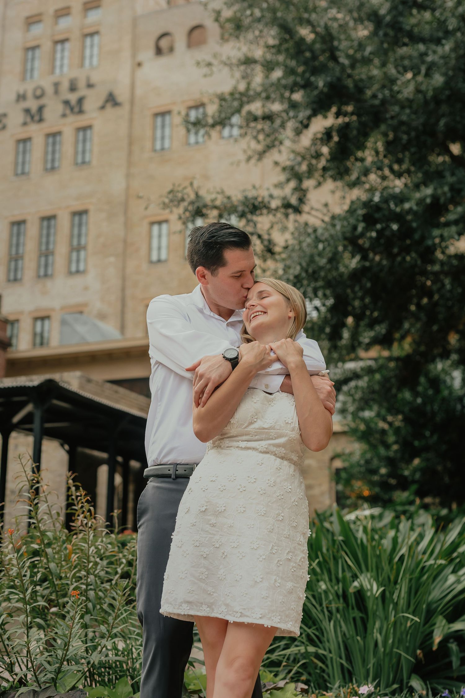 Couple sharing a joyful moment outside a historic brick building.