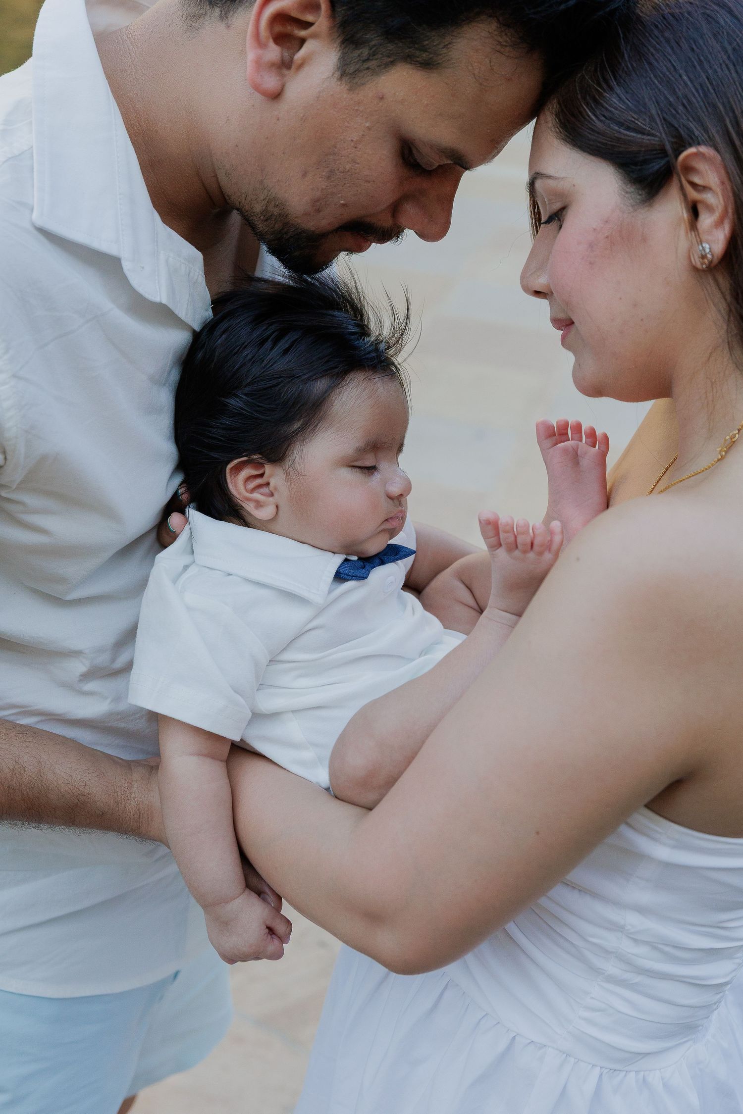 A tender family moment captured in a series of intimate photos showing parents bonding with their young child.