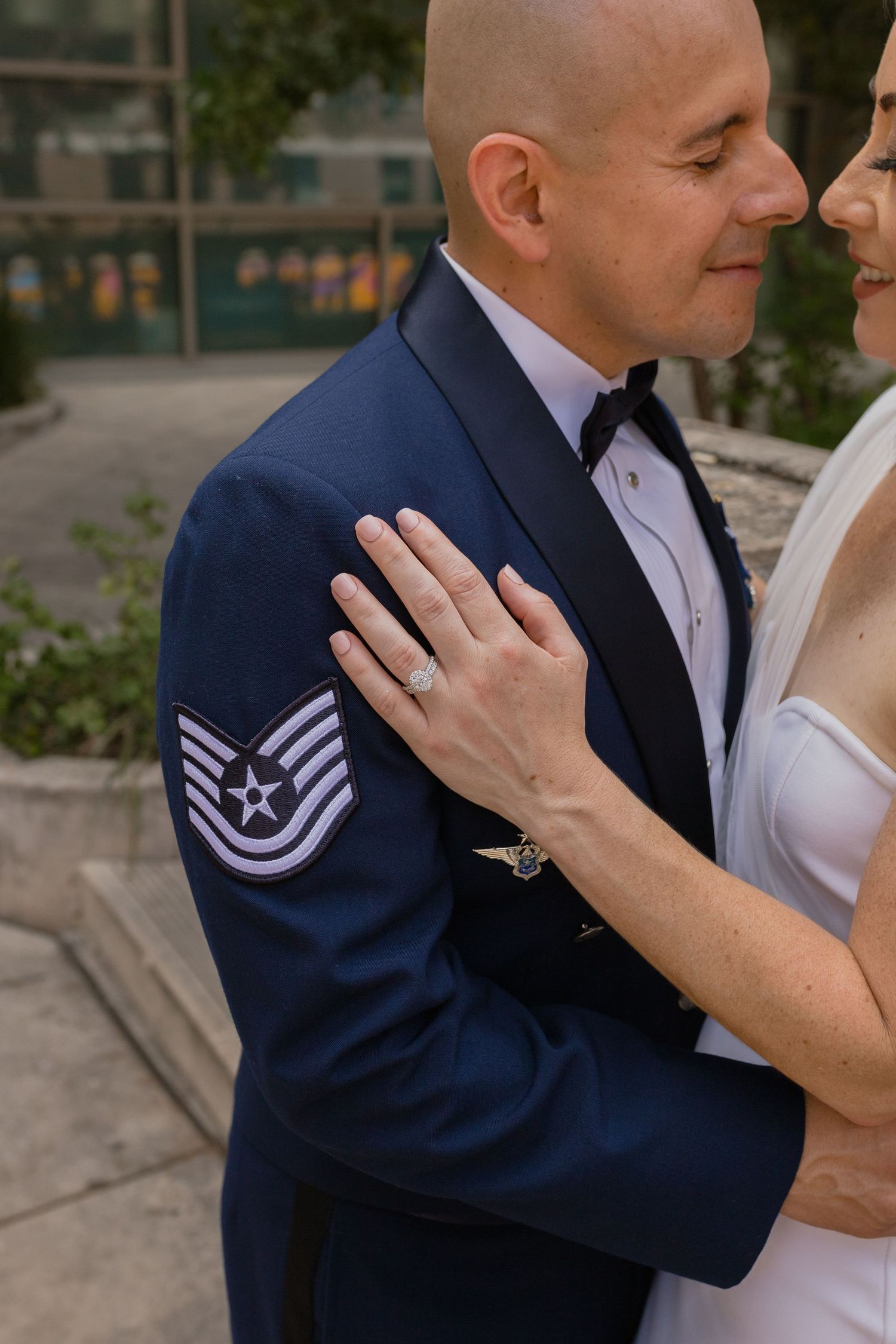 Close-up of a military service member's dress uniform with rank insignia and engagement ring.