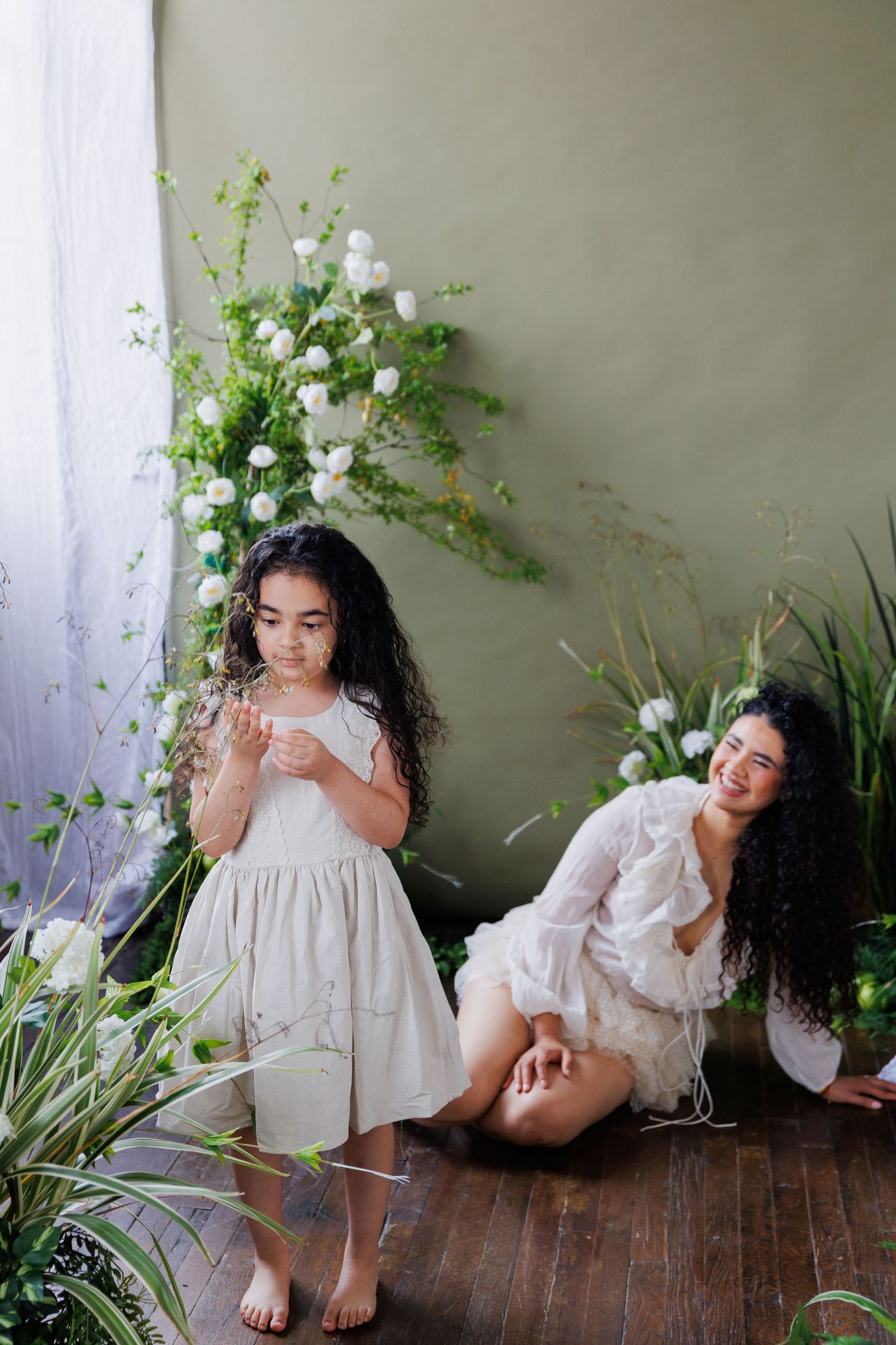 A series of artistic portraits featuring someone in a white dress with floral arrangements on a wooden floor.
