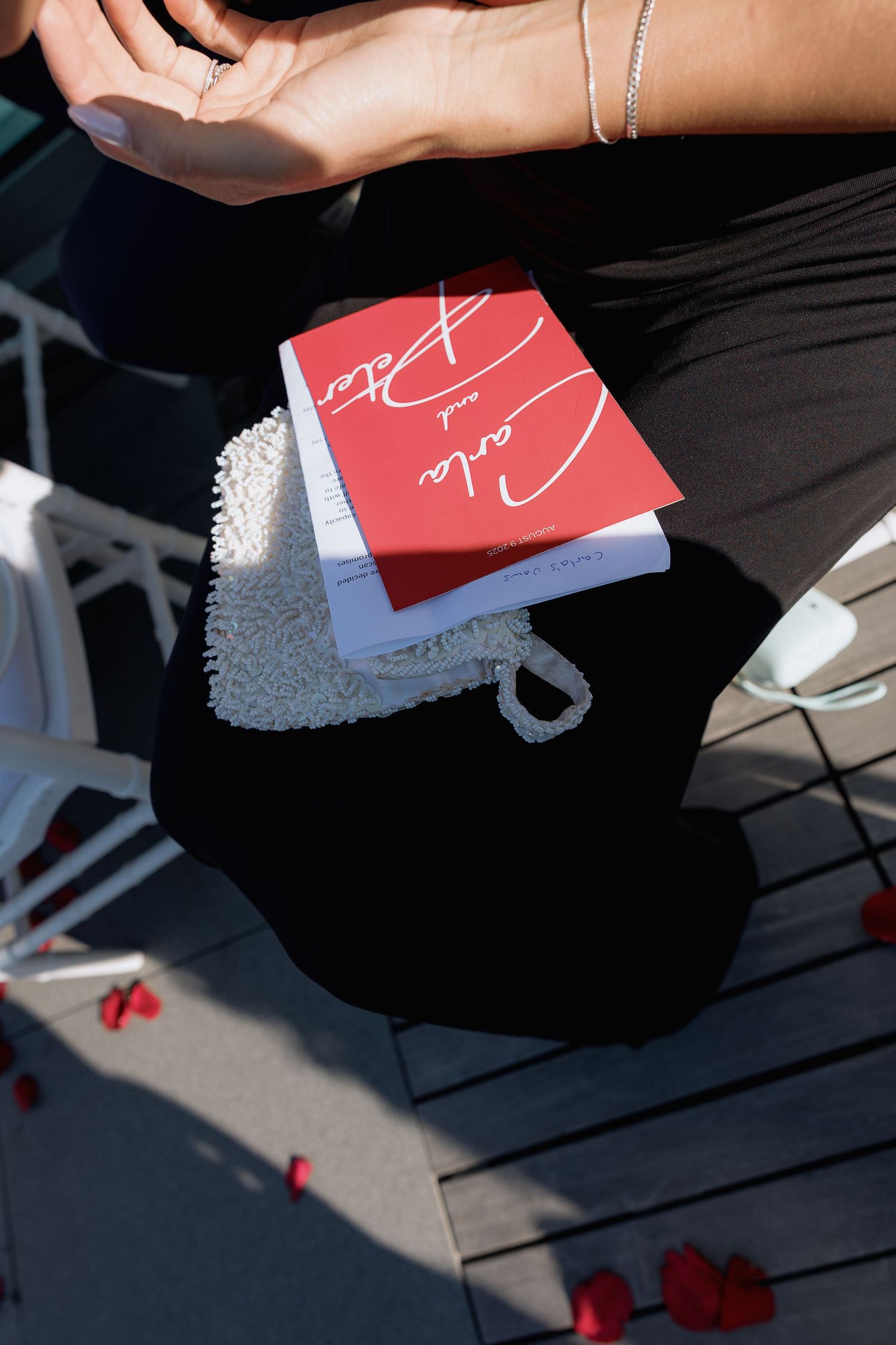 Red and white wedding cards and decorative elements arranged on a dark surface.