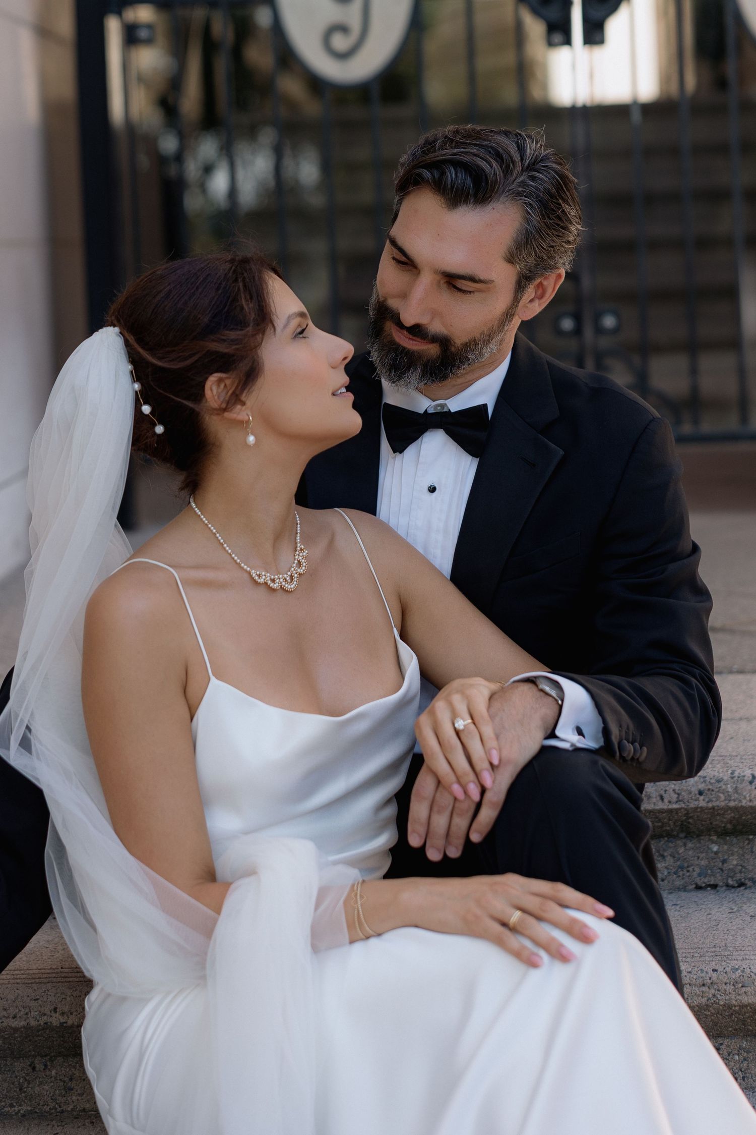 Intimate wedding portrait with couple in classic white dress and black tuxedo.