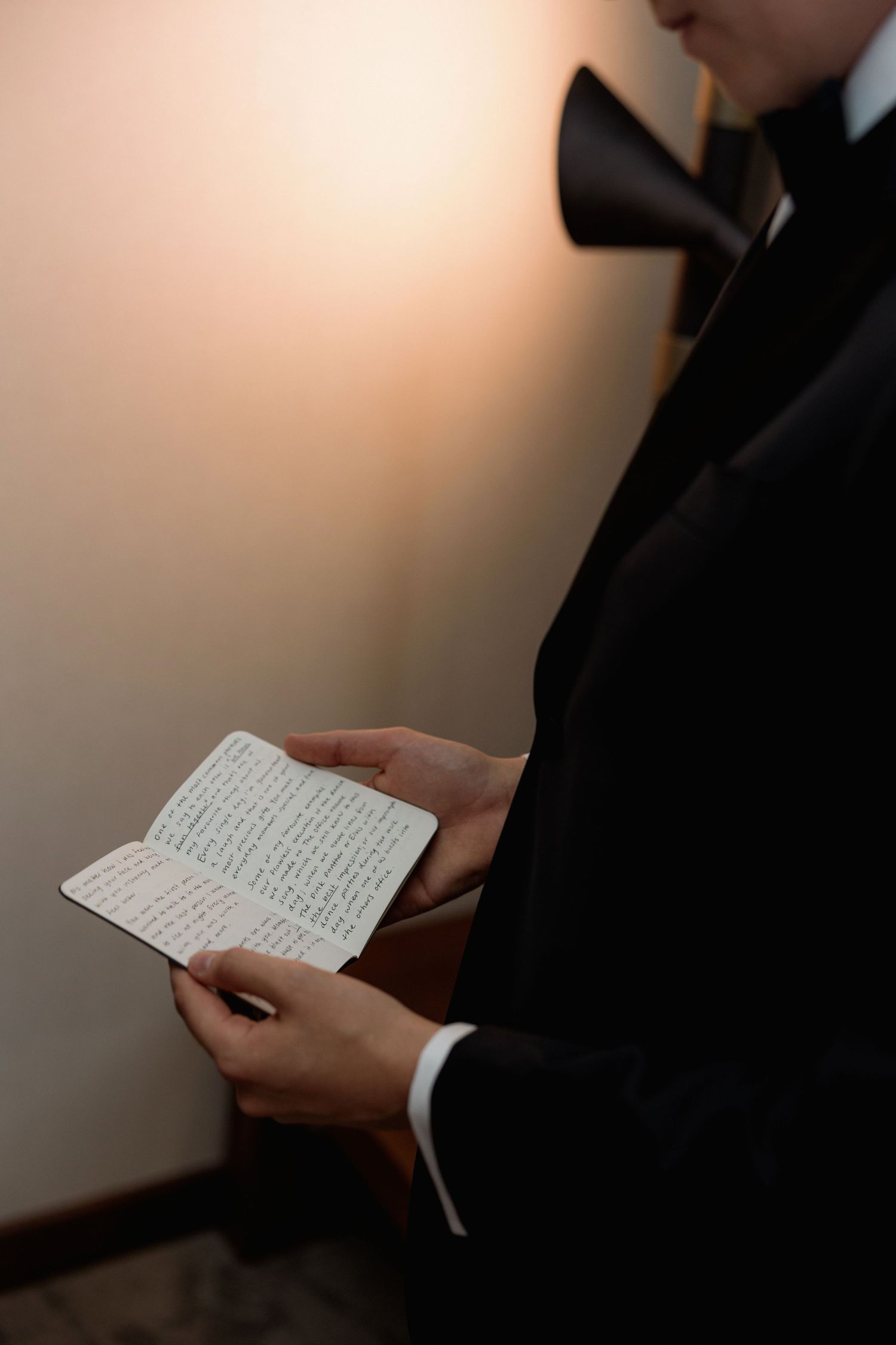Close-up of hands holding handwritten note in formal setting.