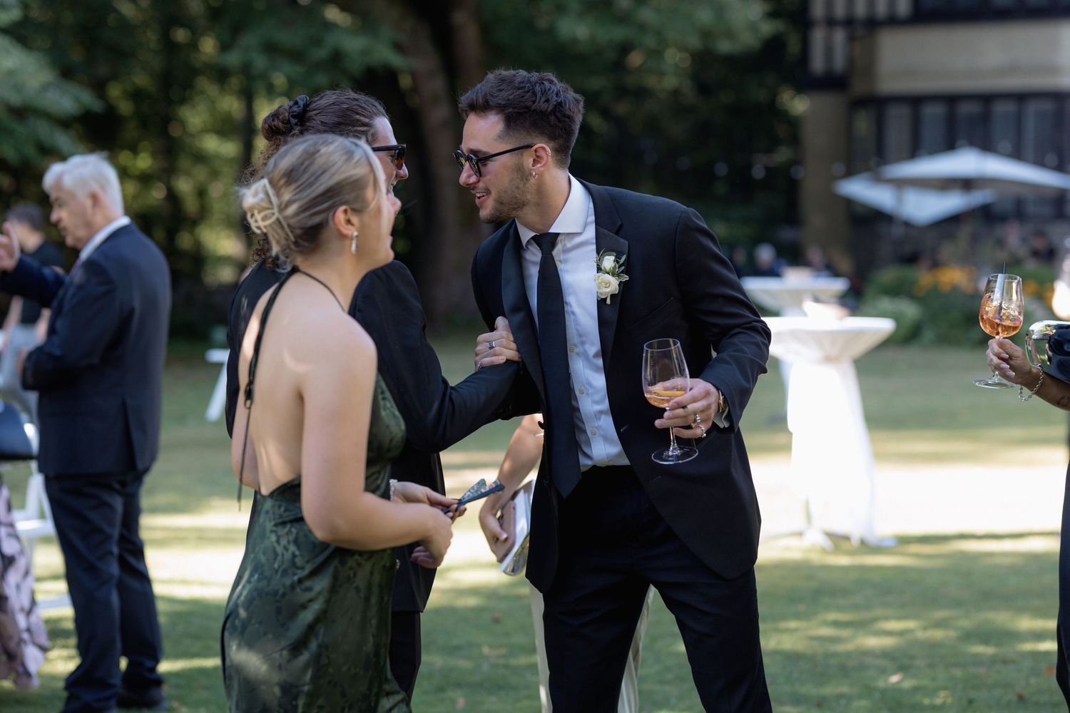 Two guests engaged in animated conversation at an outdoor social gathering.