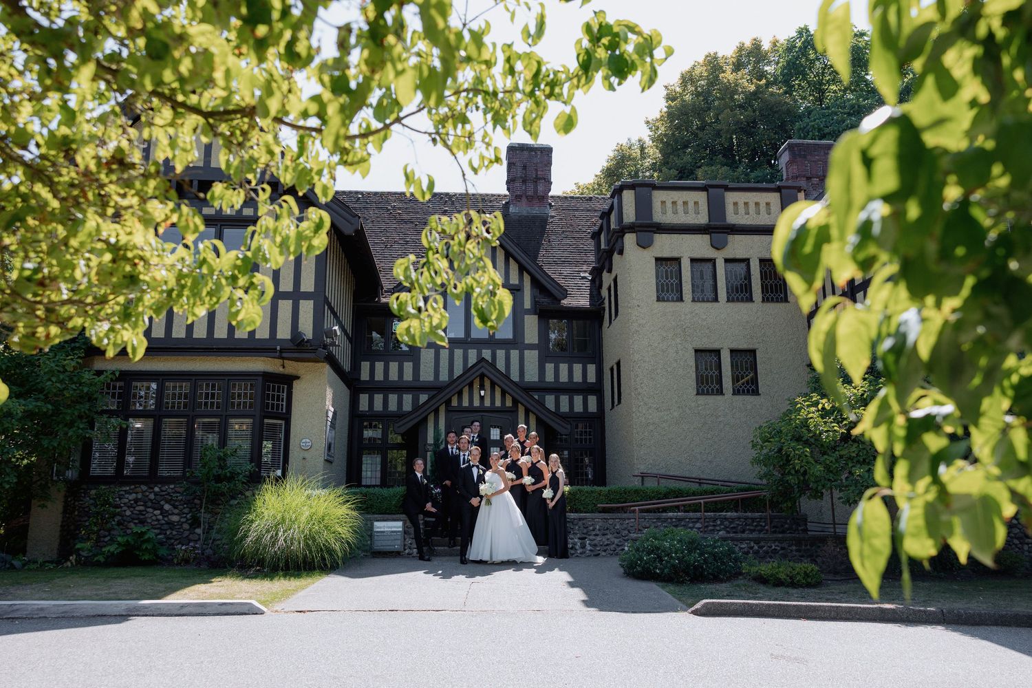 Elegant Tudor-style mansion serves as backdrop for outdoor wedding photo at Hurt House in Burnaby