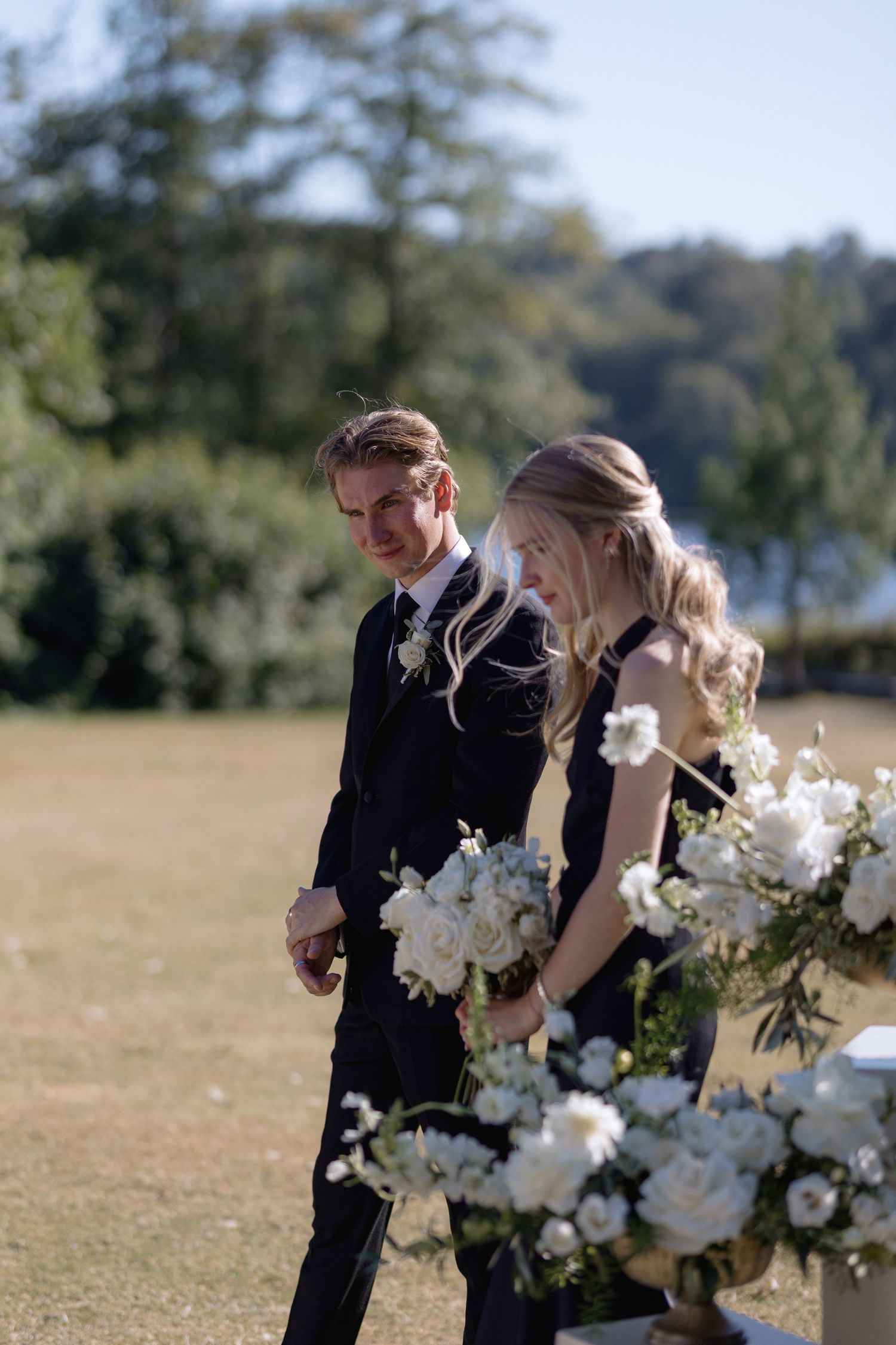 Elegant floral arrangements with white blooms decorating an outdoor wedding setting.