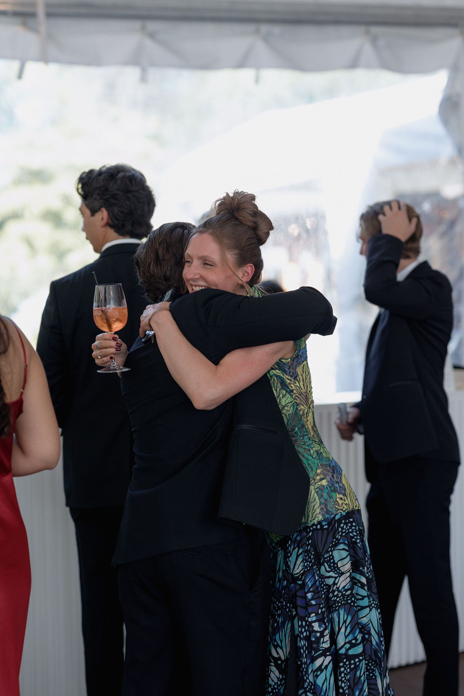 Emotional moment as guests embrace during a formal celebration.